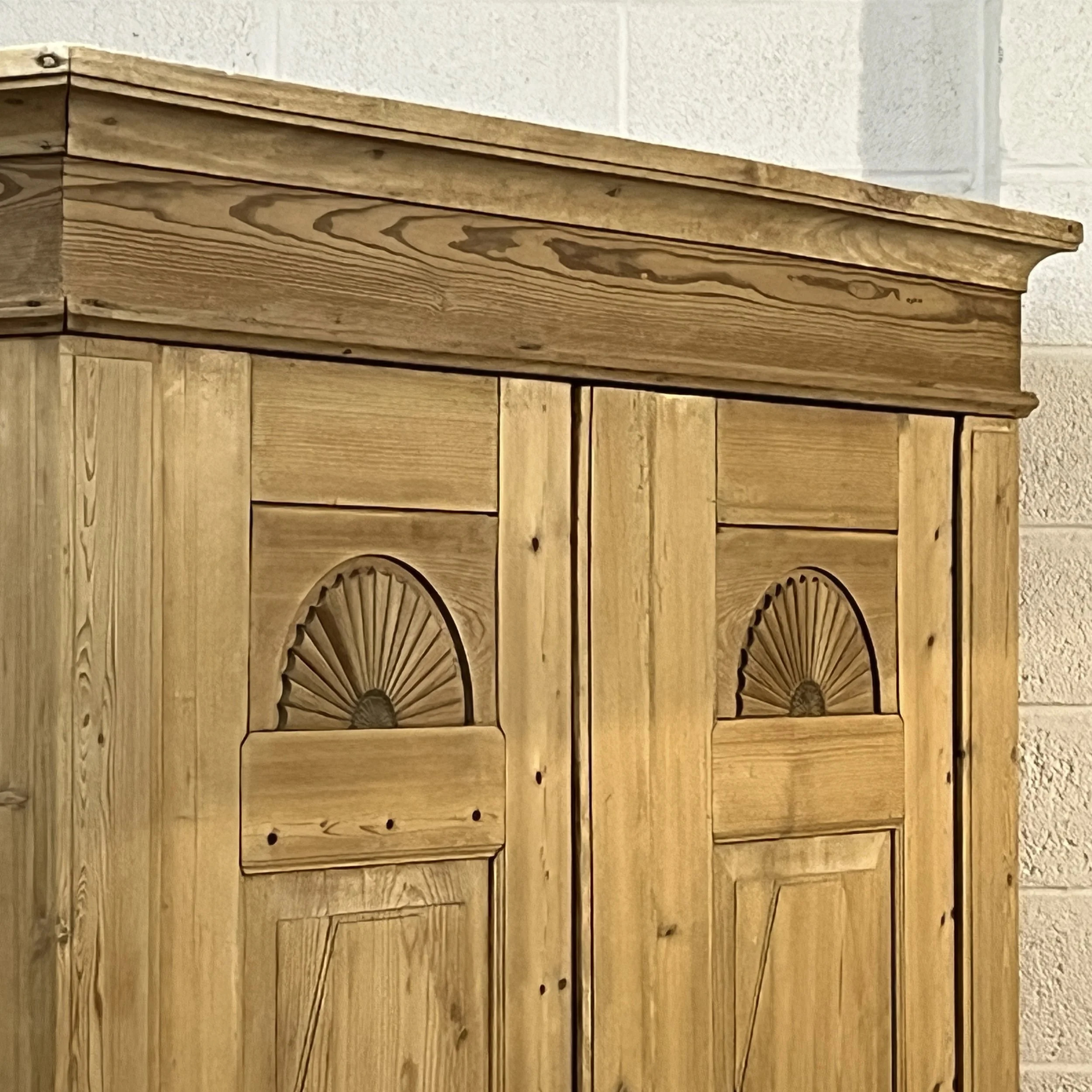 Close-up of carved fan motifs, door panels and broad cornice on old pine wardrobe N8206H.