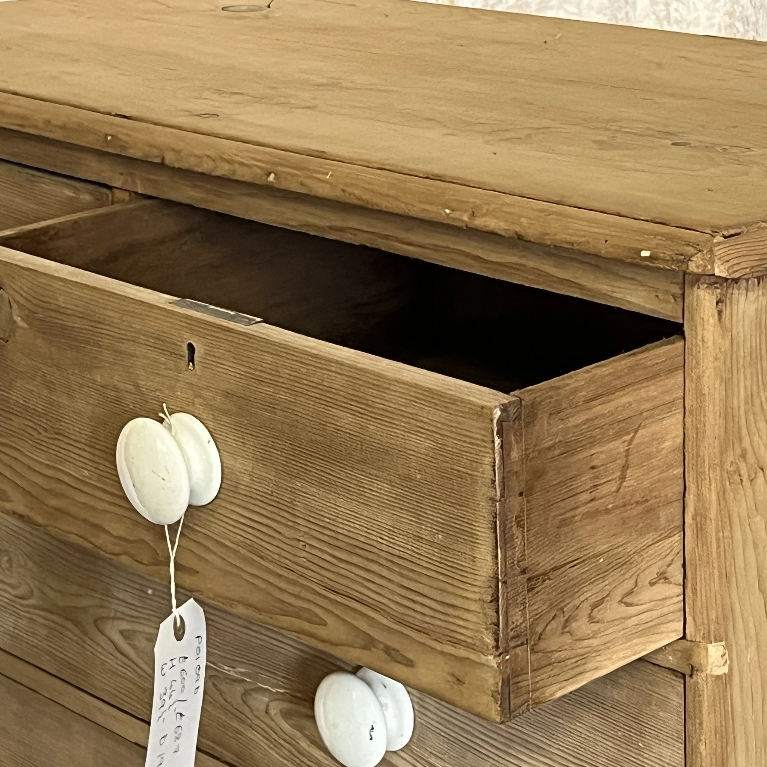 P0109B pine chest detail of open top drawer, dovetail joints, white ceramic knob and worn top edge