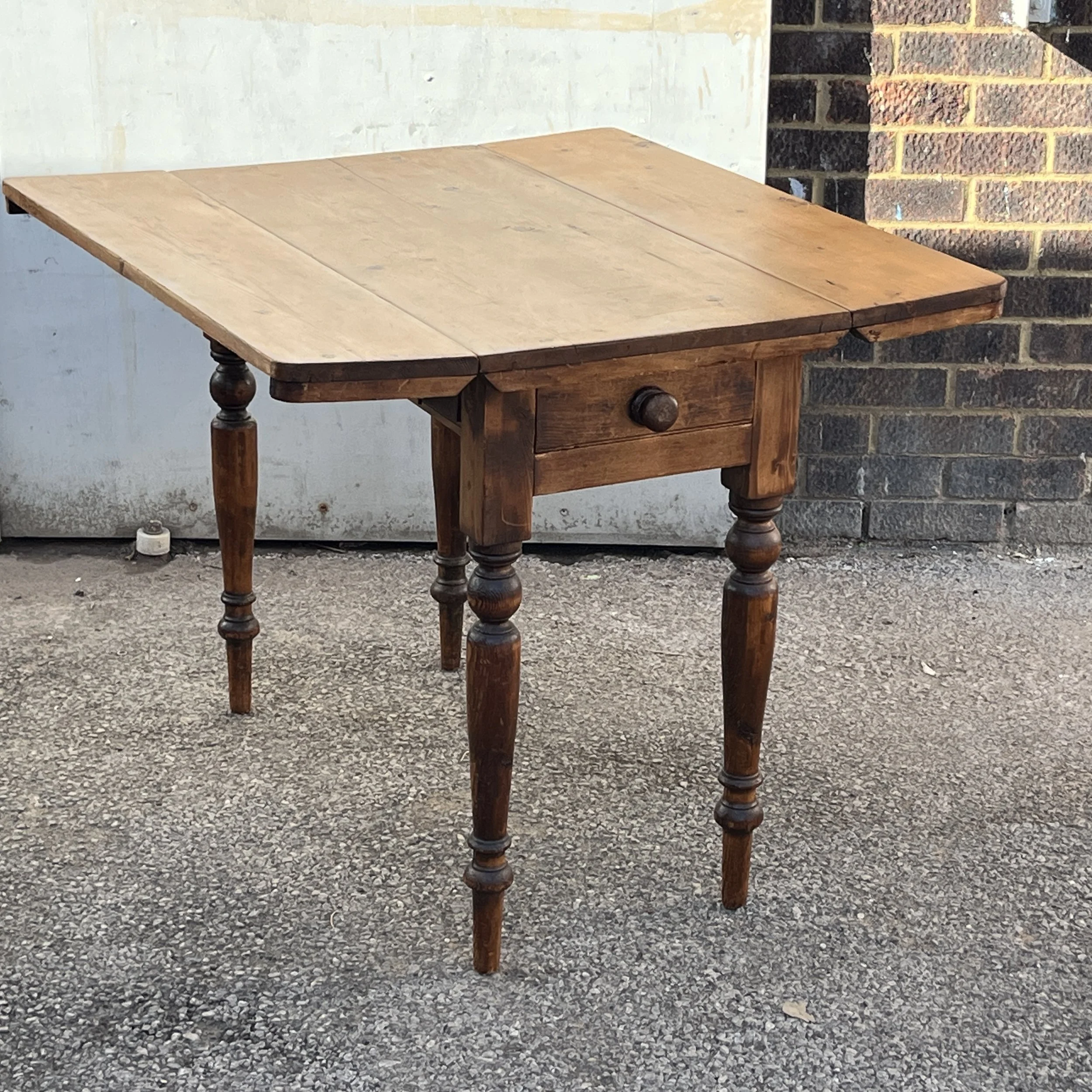 Pine drop-leaf table with both leaves raised to show the full tabletop