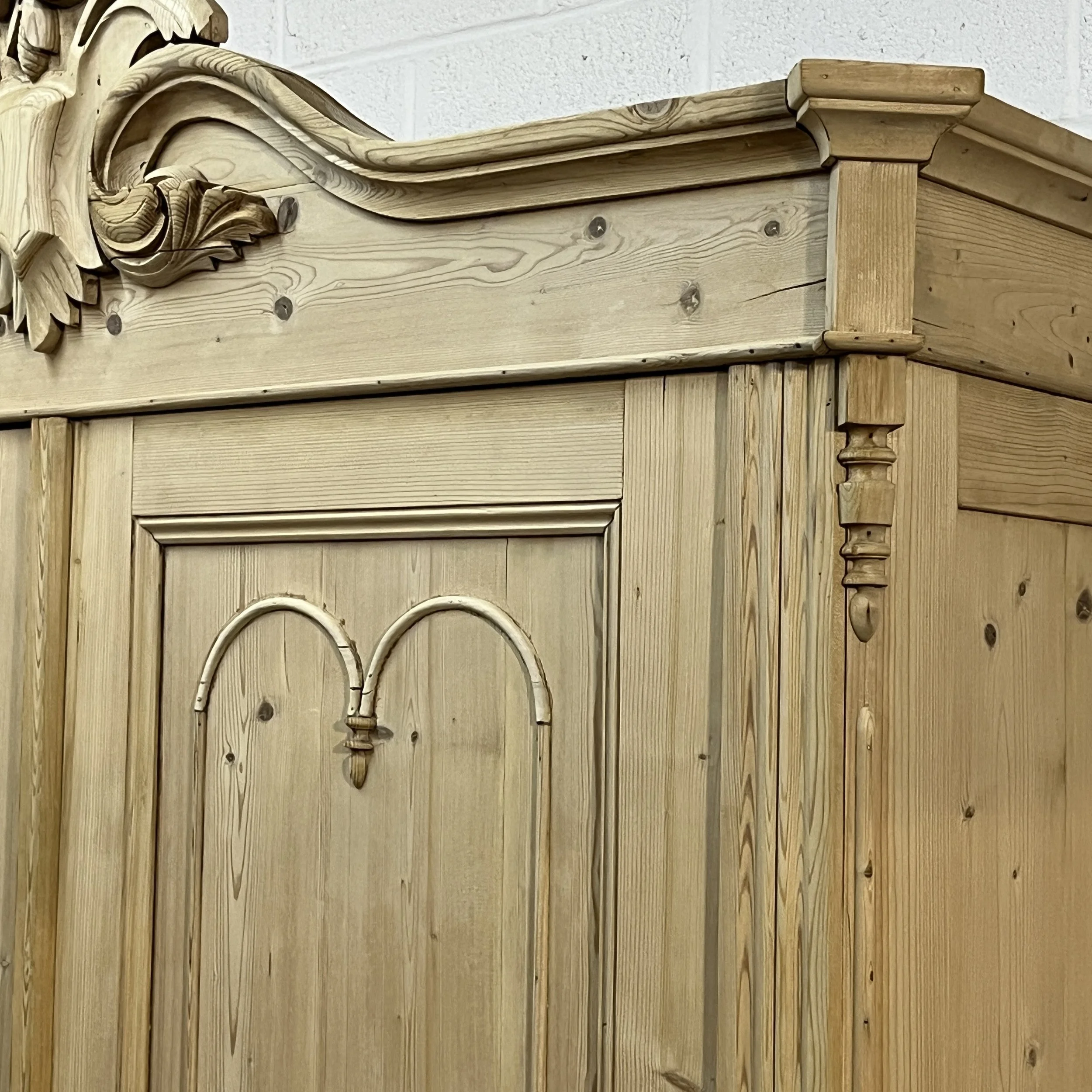 Detail of the pine wardrobe upper door panels, carved cornice and side pilaster