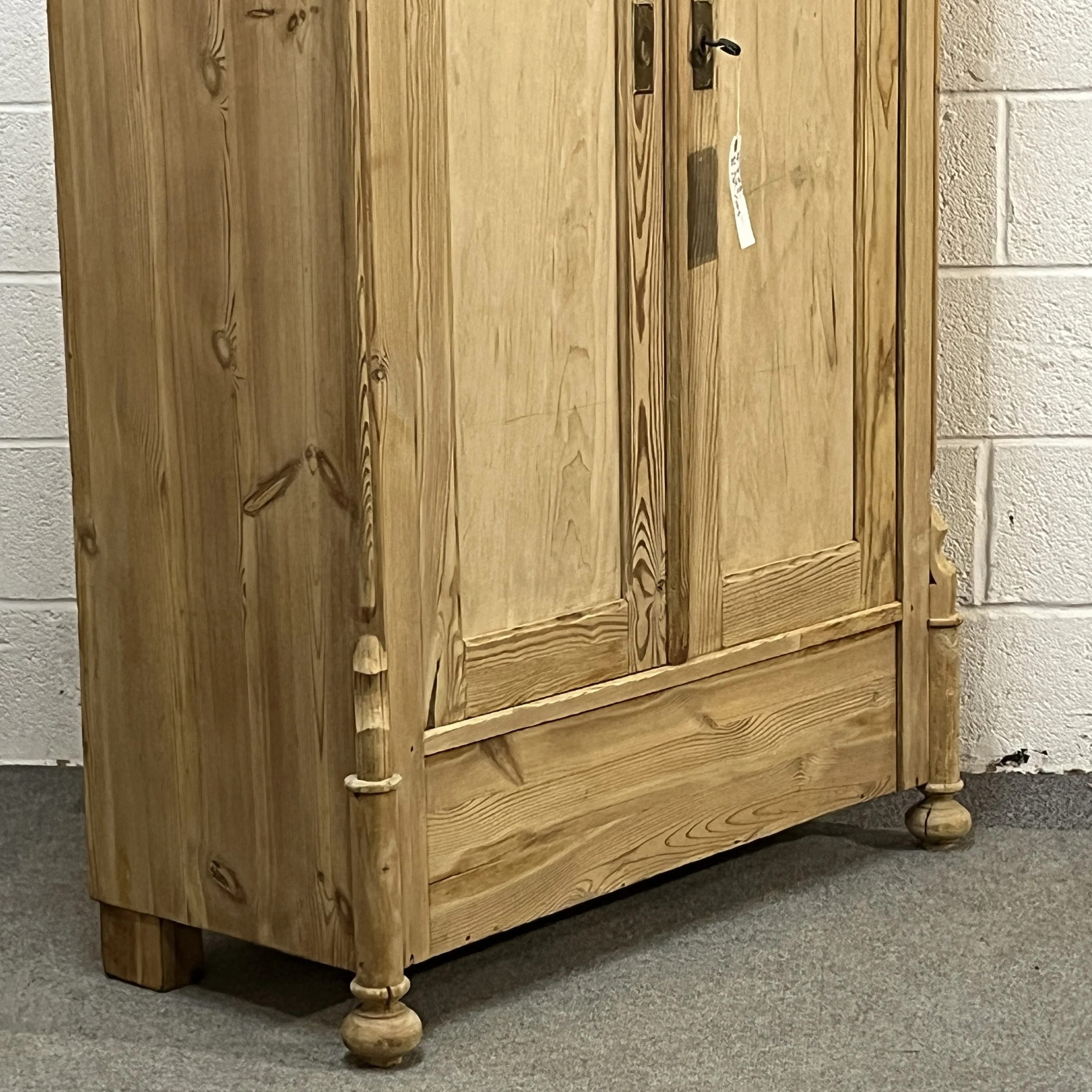 Detail of the lower door panels and feet of pine armoire N3304D