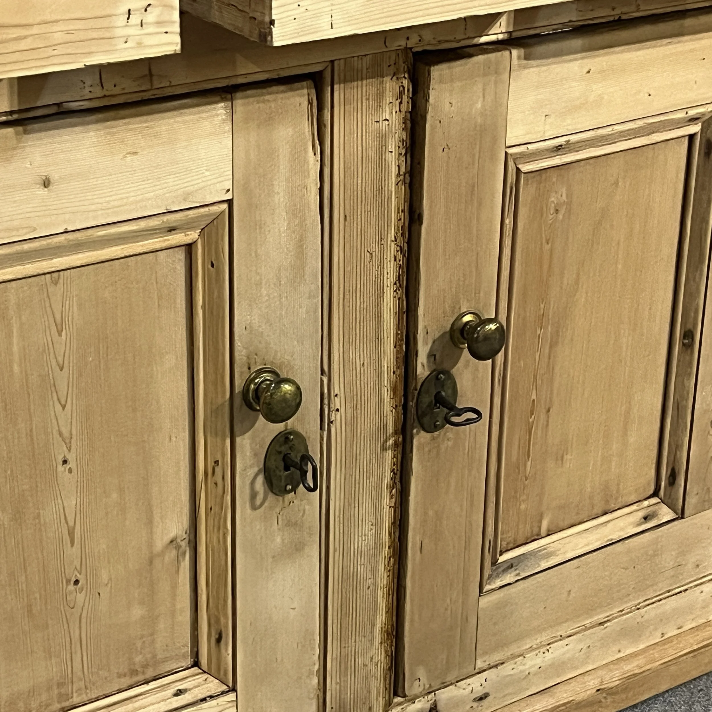 Lower panelled doors, brass knobs and keys on pine housekeeper’s cupboard N7700I