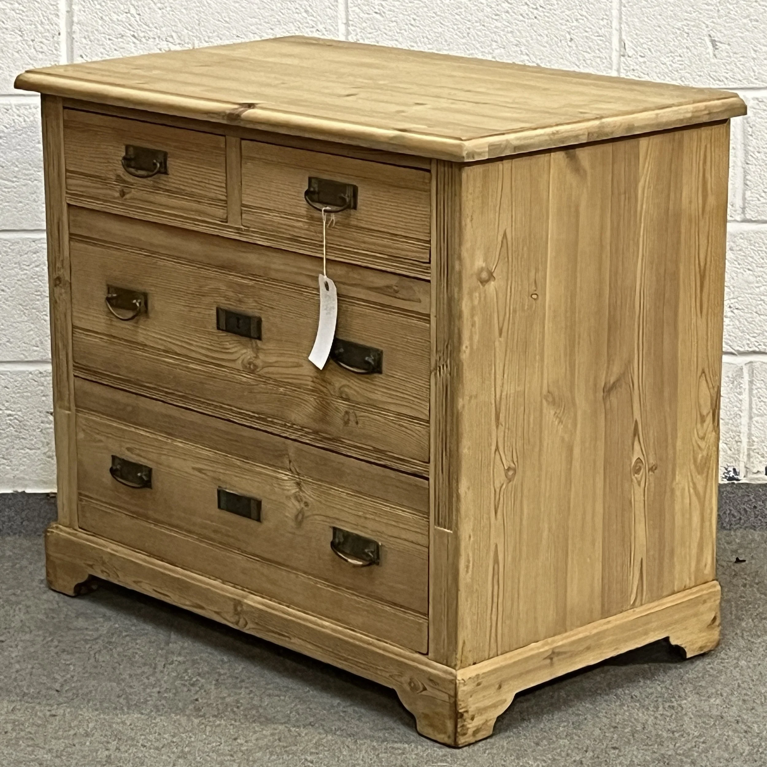 Small 1930s pine chest N8004C viewed from the right, showing the pine side panel, rounded top and bracket feet.