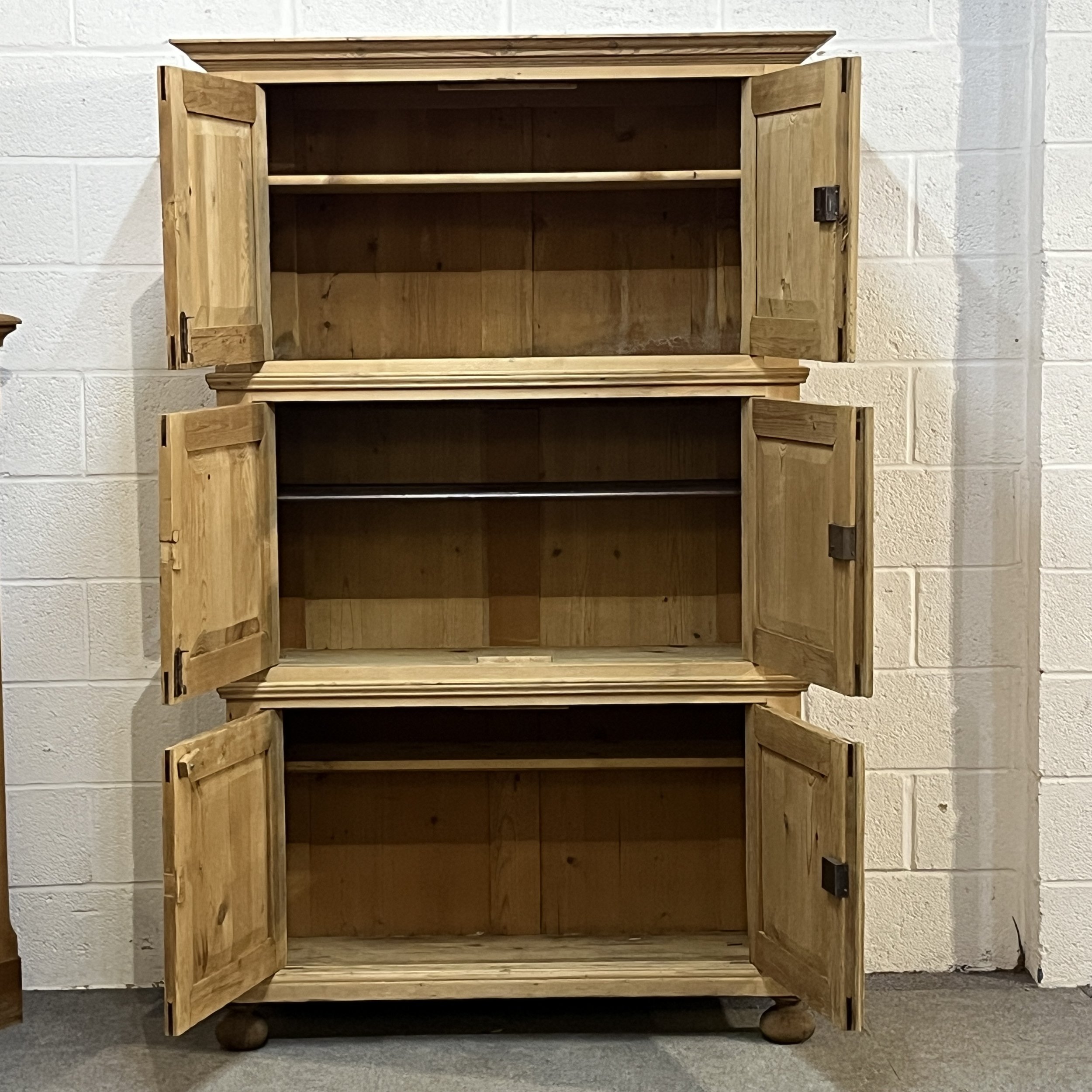 Pine campaign cupboard with all six doors open, showing its shelves and storage compartments