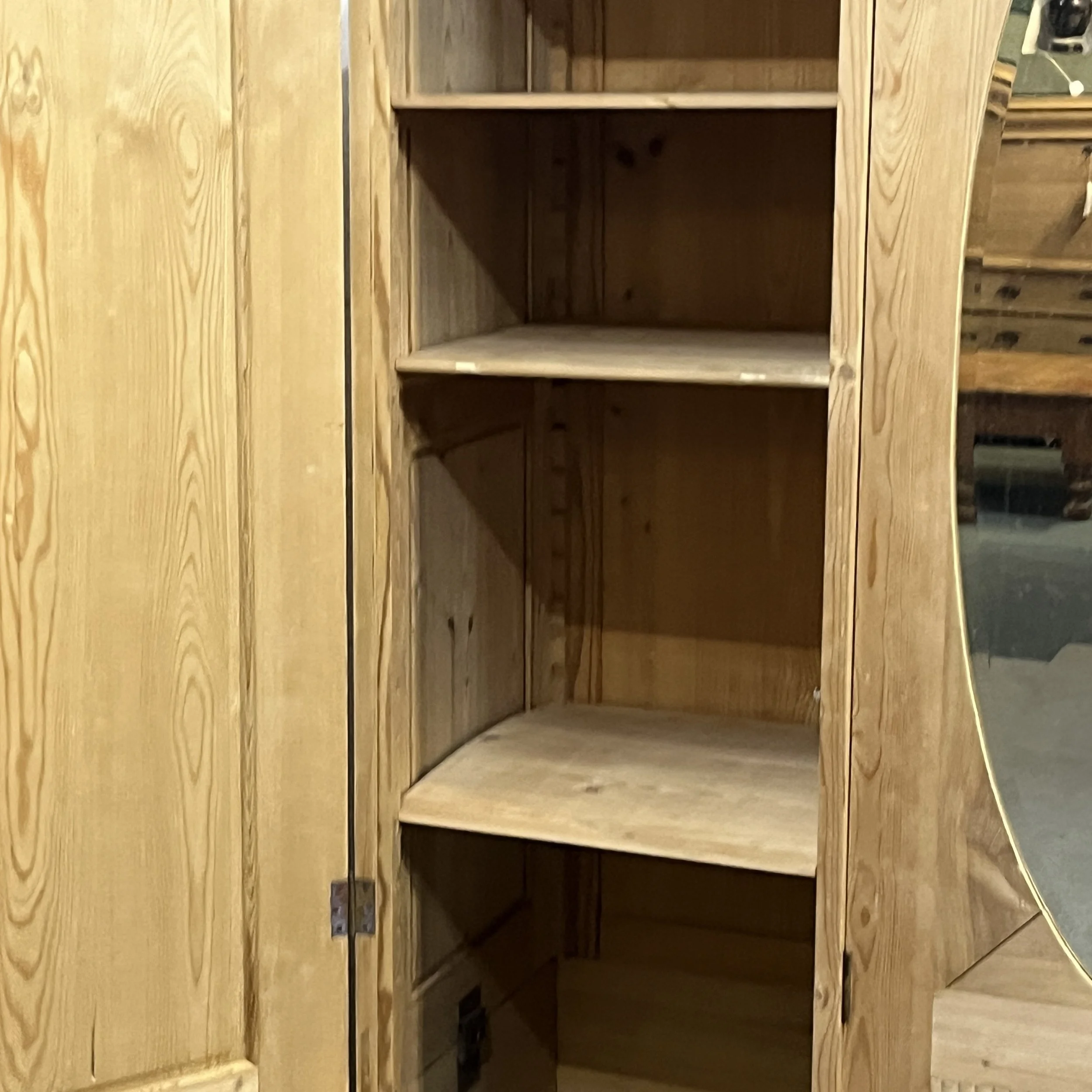 Close view of the shelves behind the pine wardrobe left door