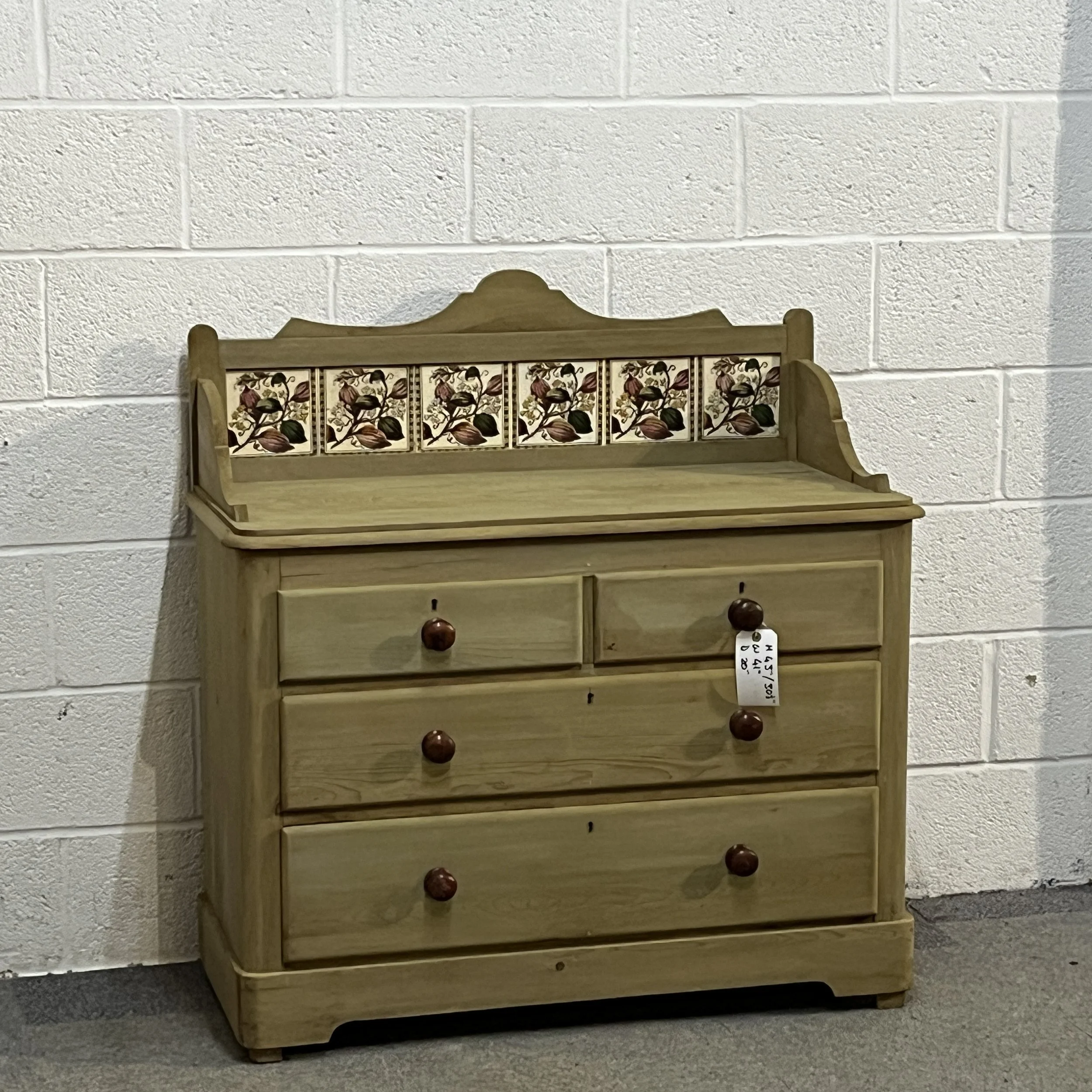 Front view of the Victorian pine chest of drawers with original floral tiled splashback