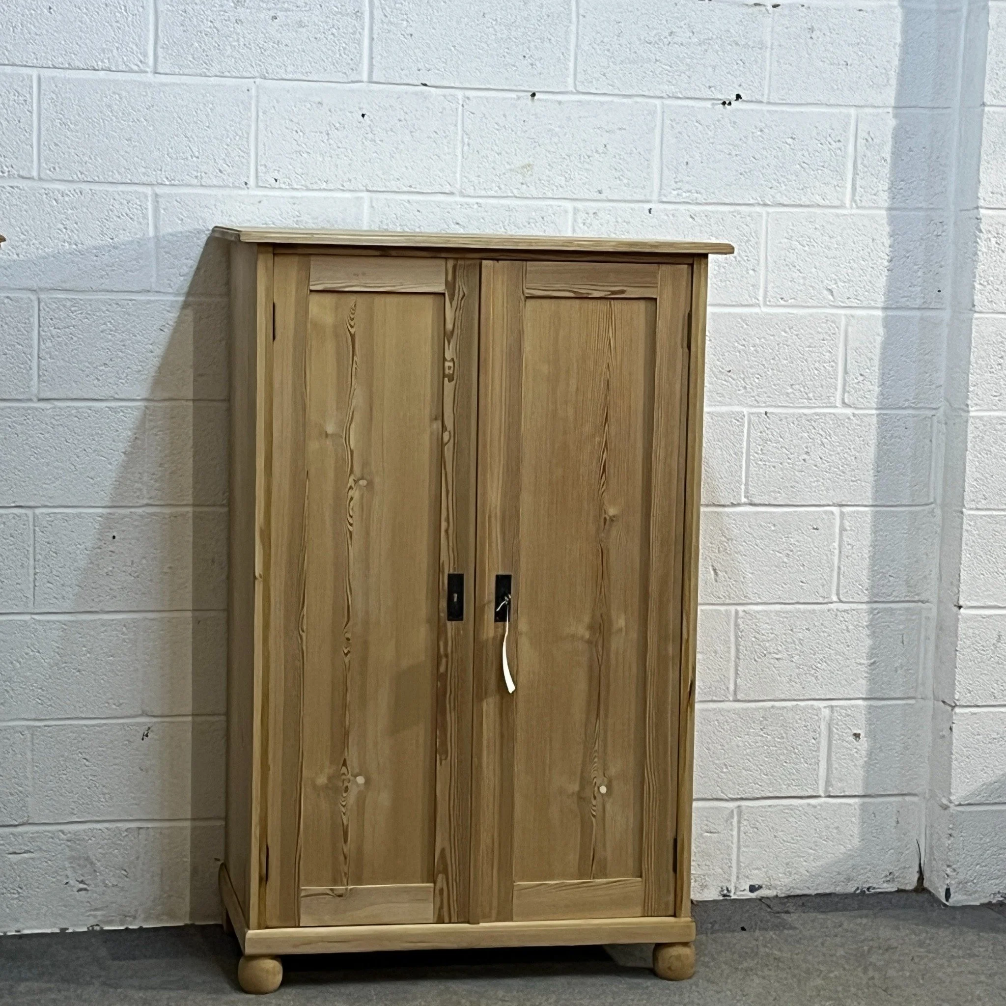 N7600D pine cupboard — full front view with two panelled doors and bun feet