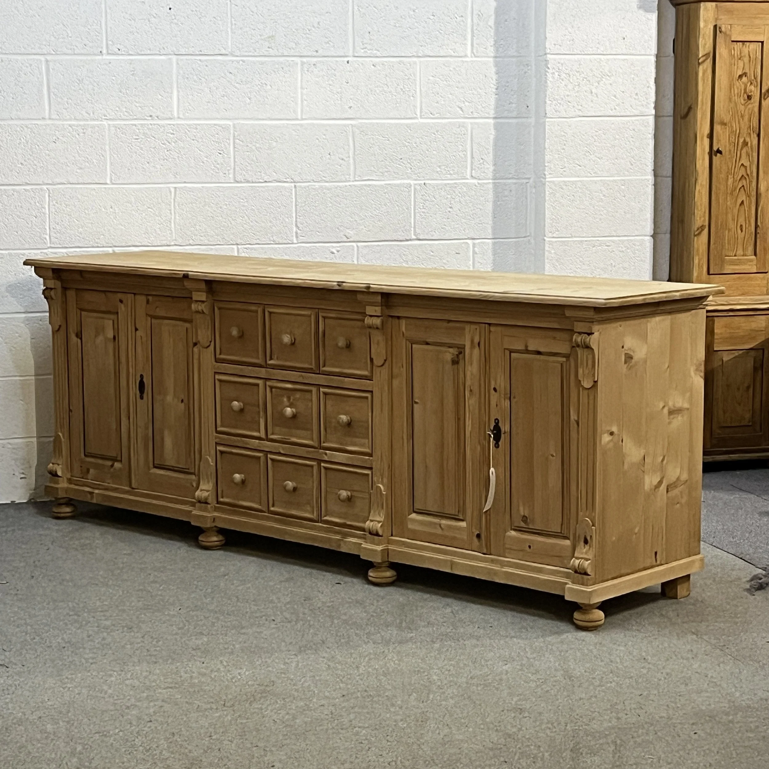 Right angled full view of bare pine sideboard N7102E showing its solid end and broad top