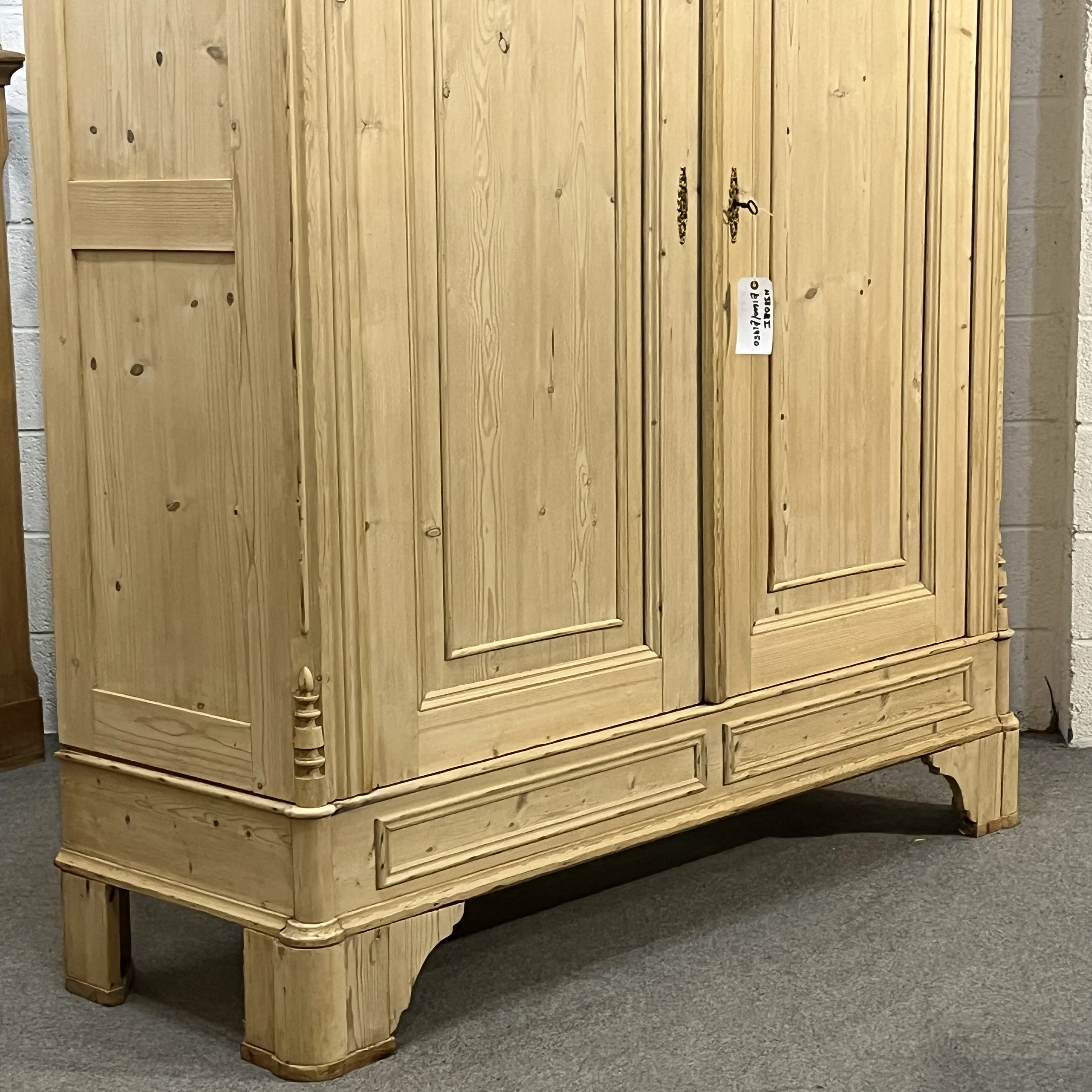 Close view of the pine wardrobe lower door panels, plinth and feet