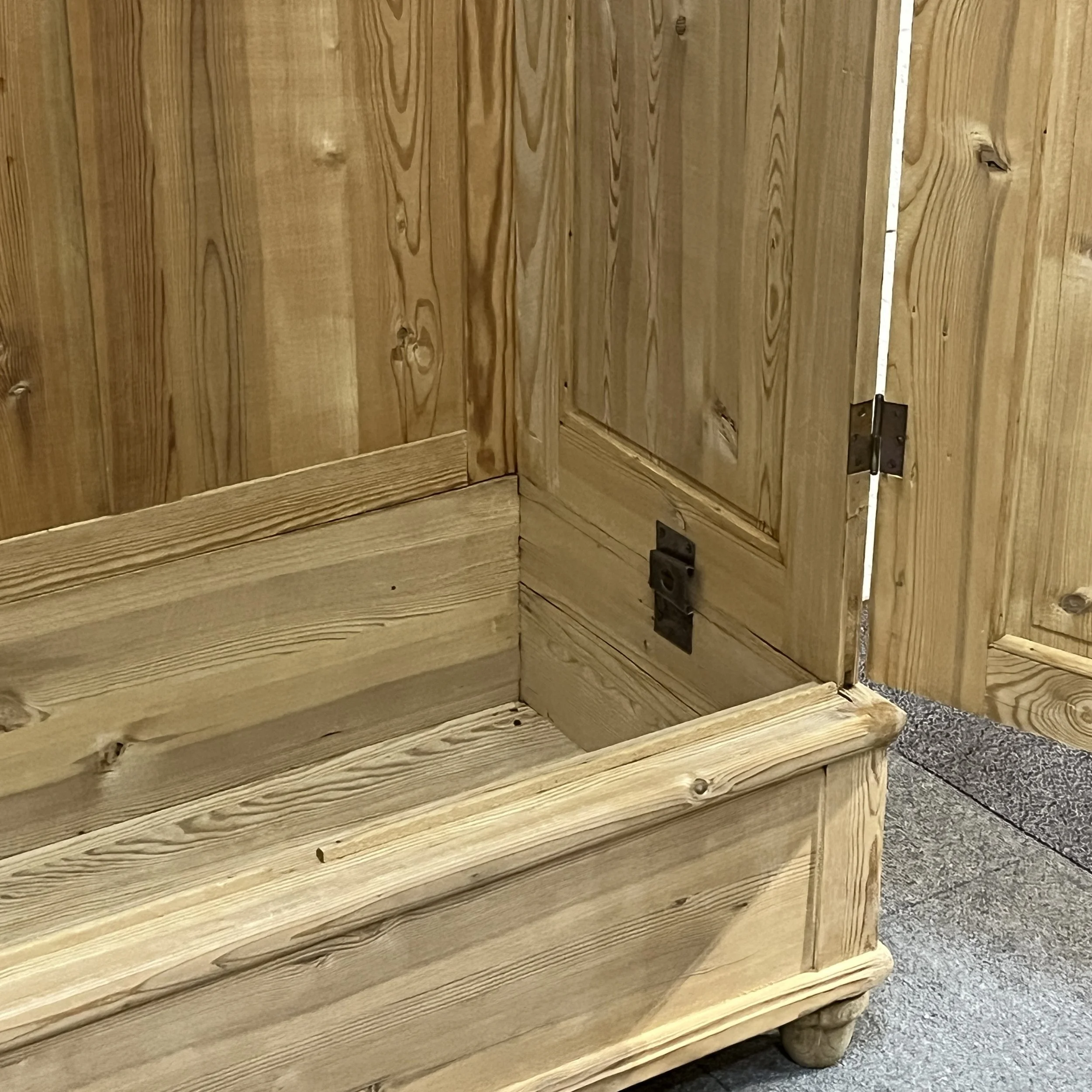 Detail inside the pine wardrobe showing the lower hanging space and open door