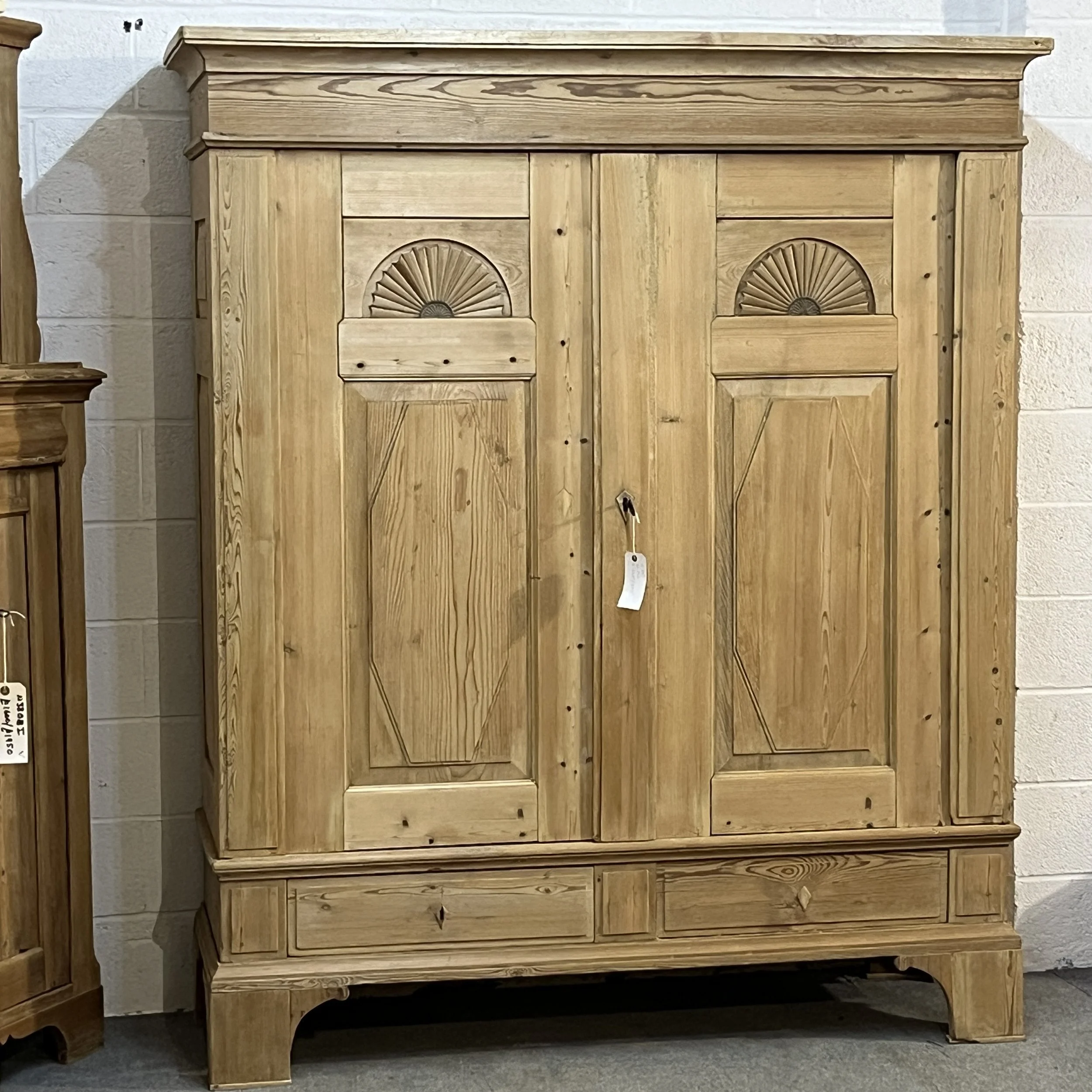 Very large old pine wardrobe N8206H, full front view with carved fan panels, broad cornice and high bracket feet.