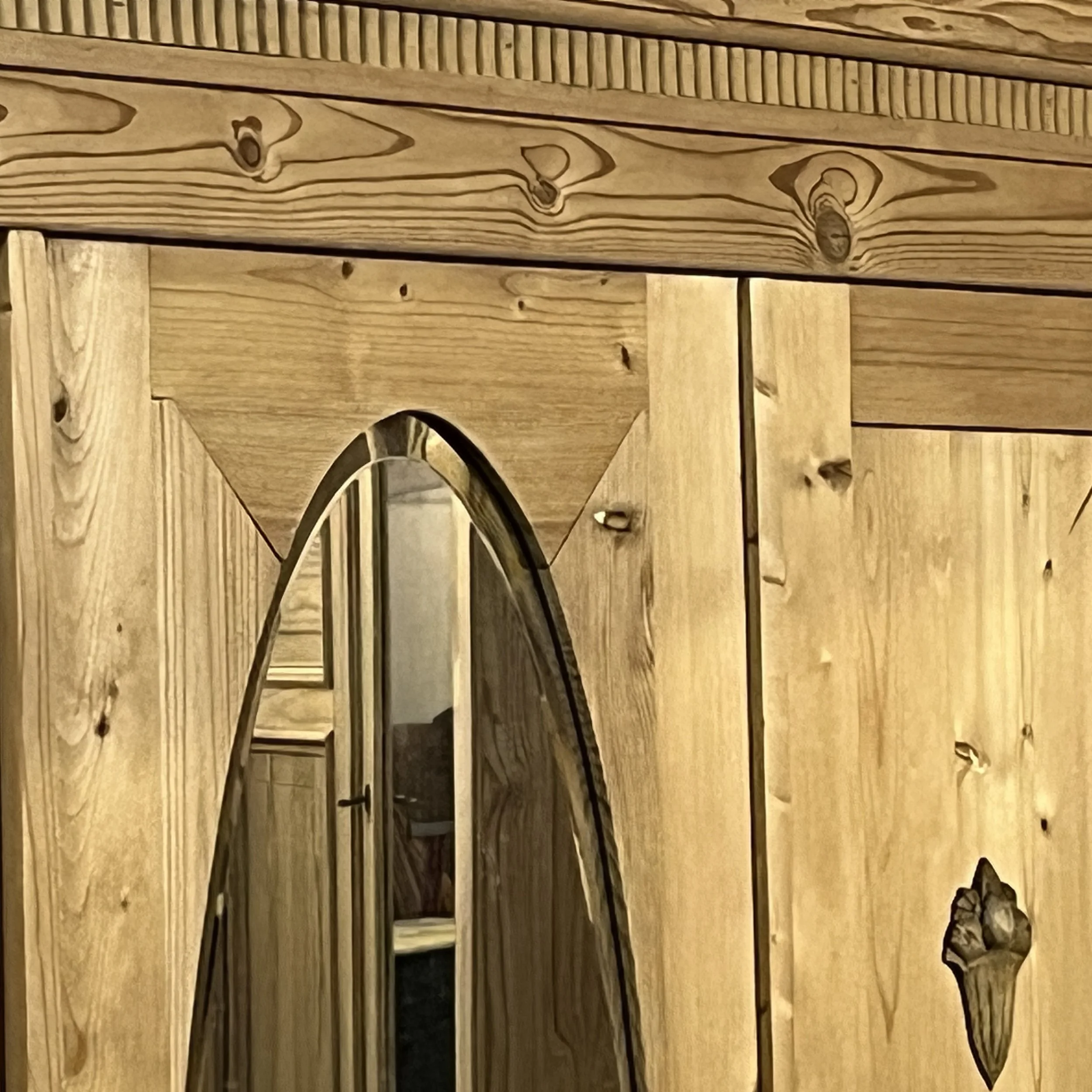 Close view of the pine wardrobe oval mirror surround and decorative upper frieze