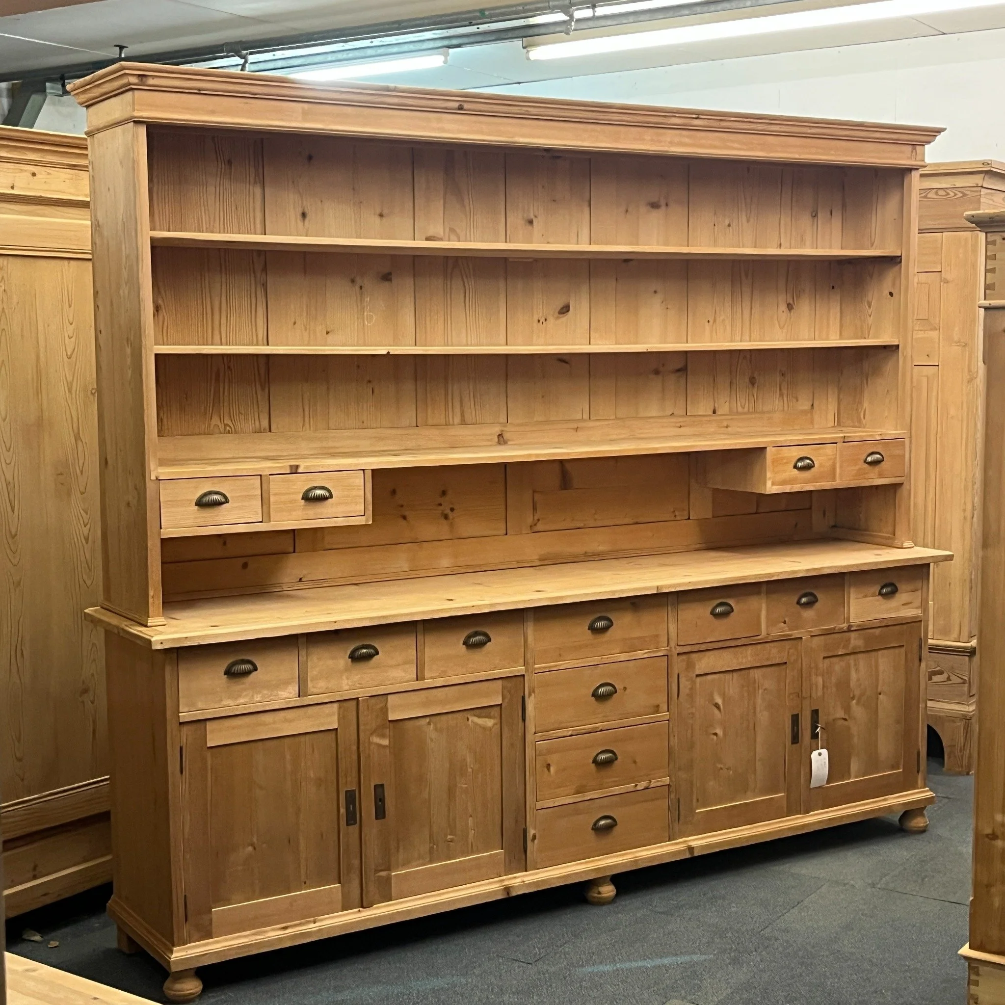 N8106J extremely large bare pine dresser — front angled view showing open rack shelves, small drawers and four-door cupboard base