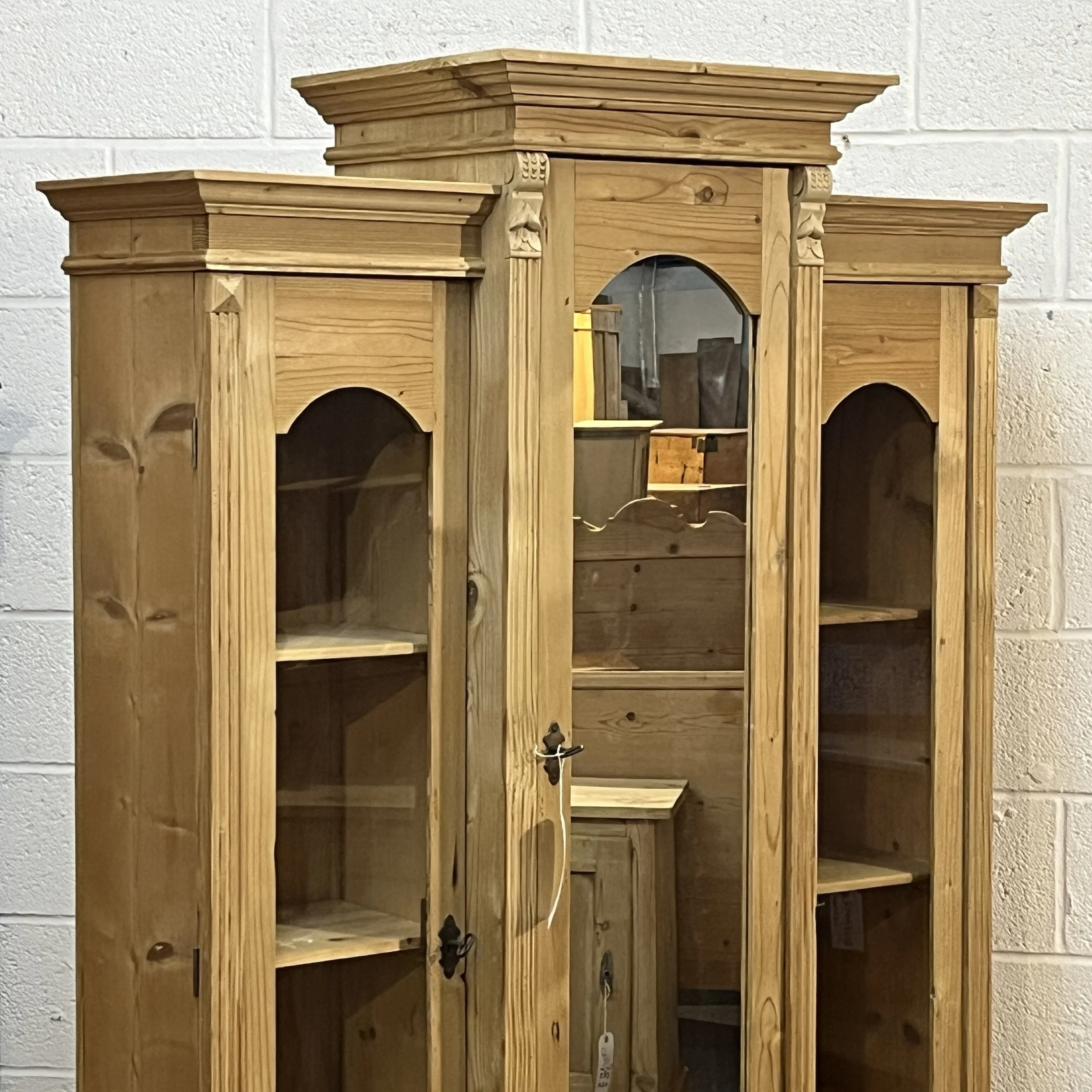 Stepped cornices, carved details and arched glazed and mirrored doors of pine cabinet N7500D