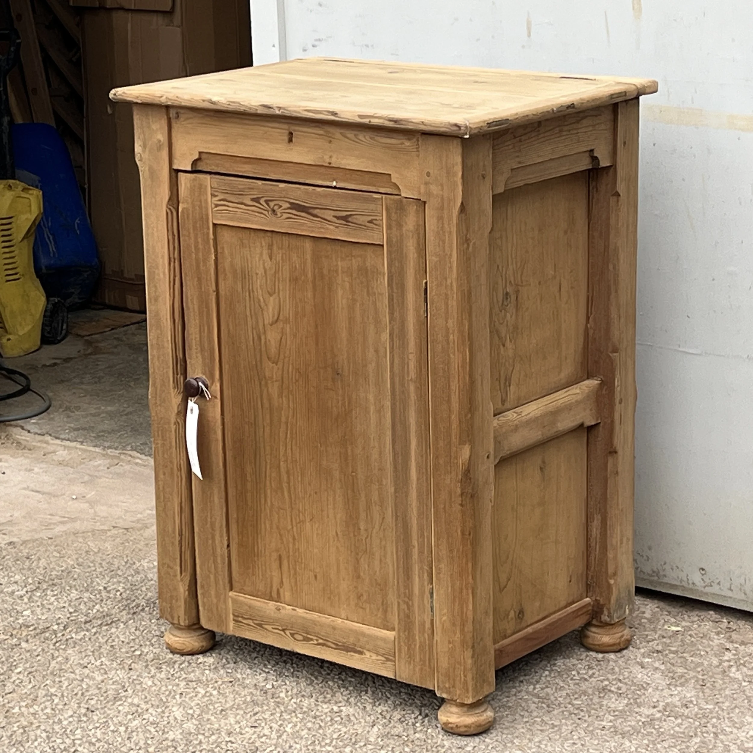 Right-side angle of pine cupboard N8802C showing panelled side and turned feet