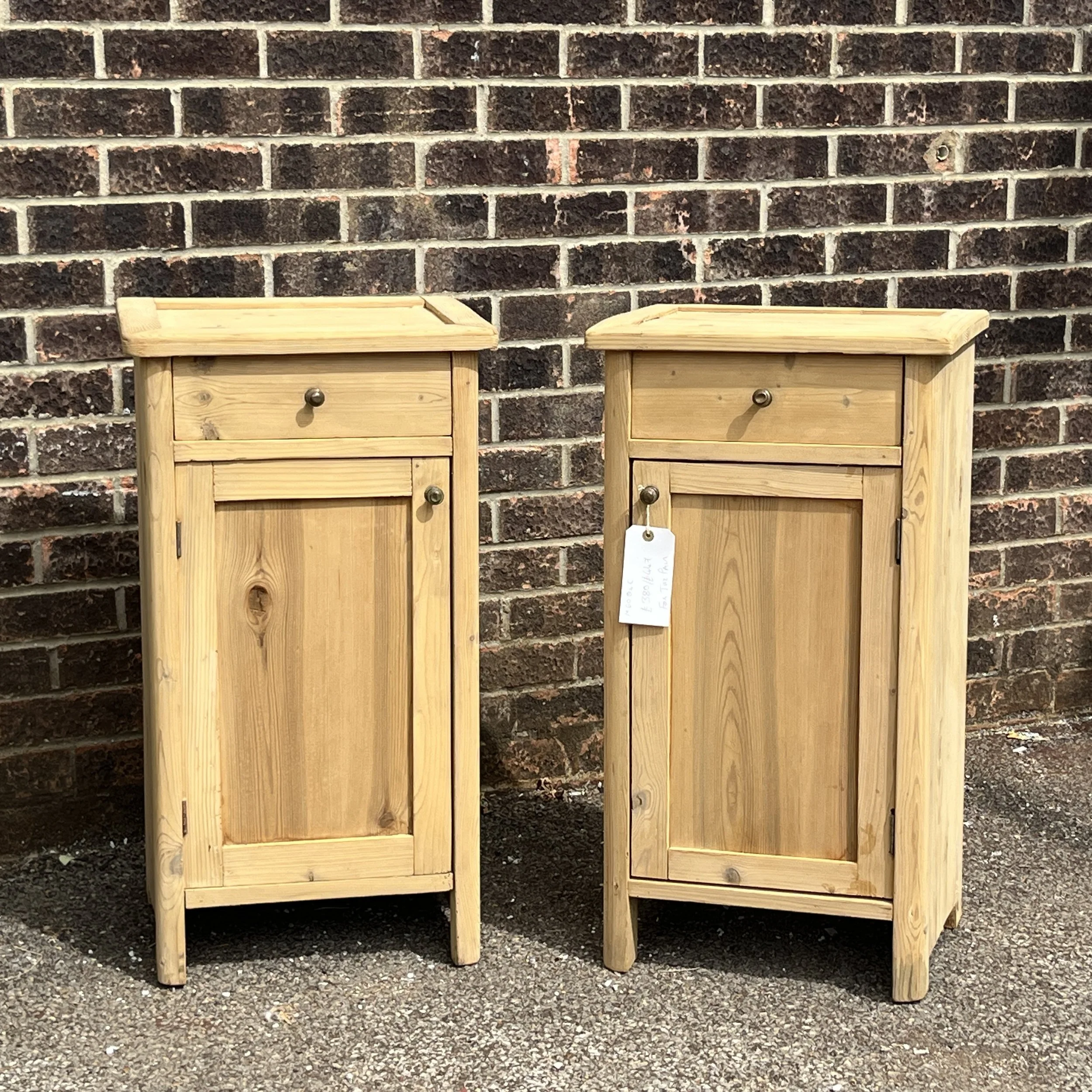 Front view of the pair of pine bedside cupboards with single drawers and panelled doors
