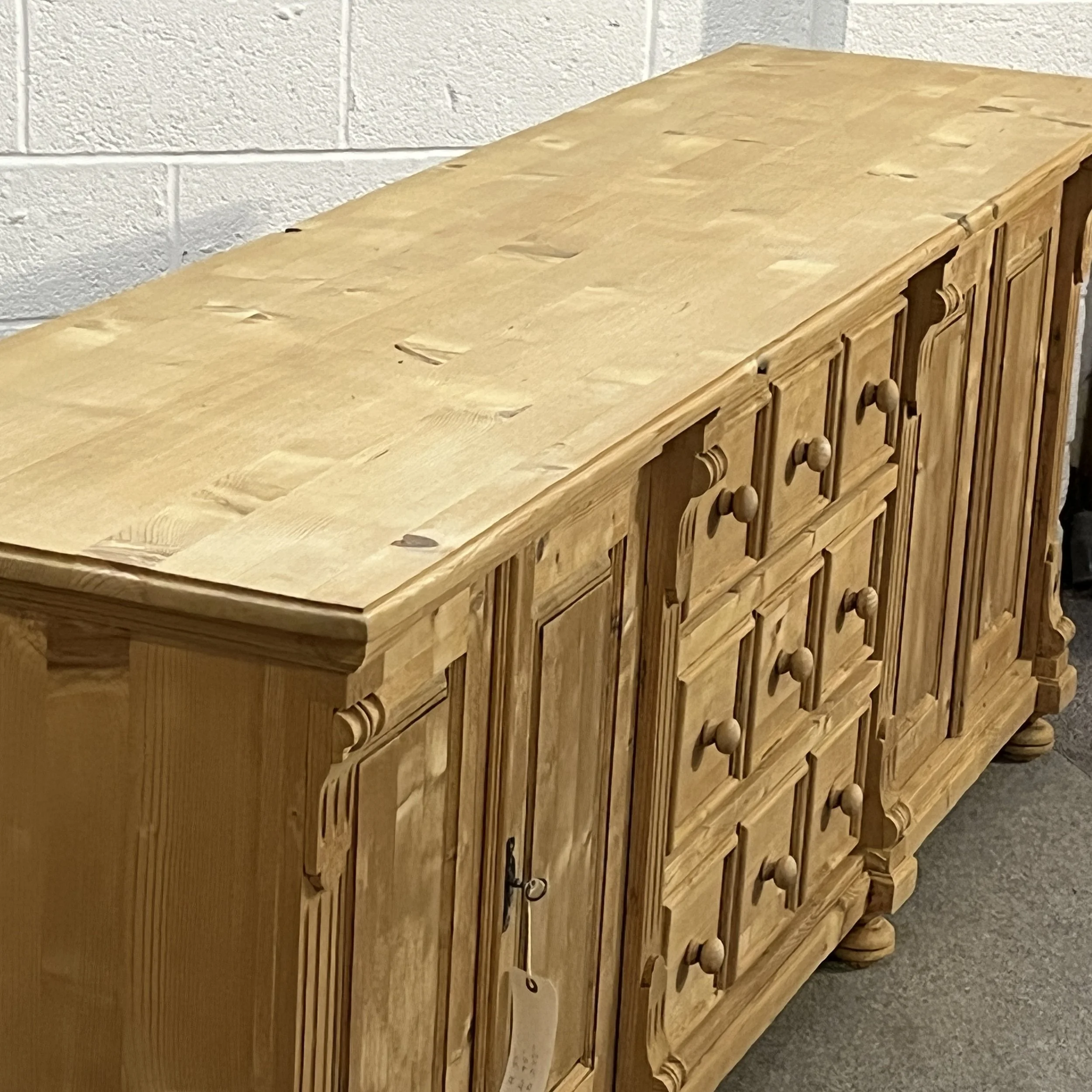 Close view of the broad pine top and panelled drawer fronts on sideboard N7102E