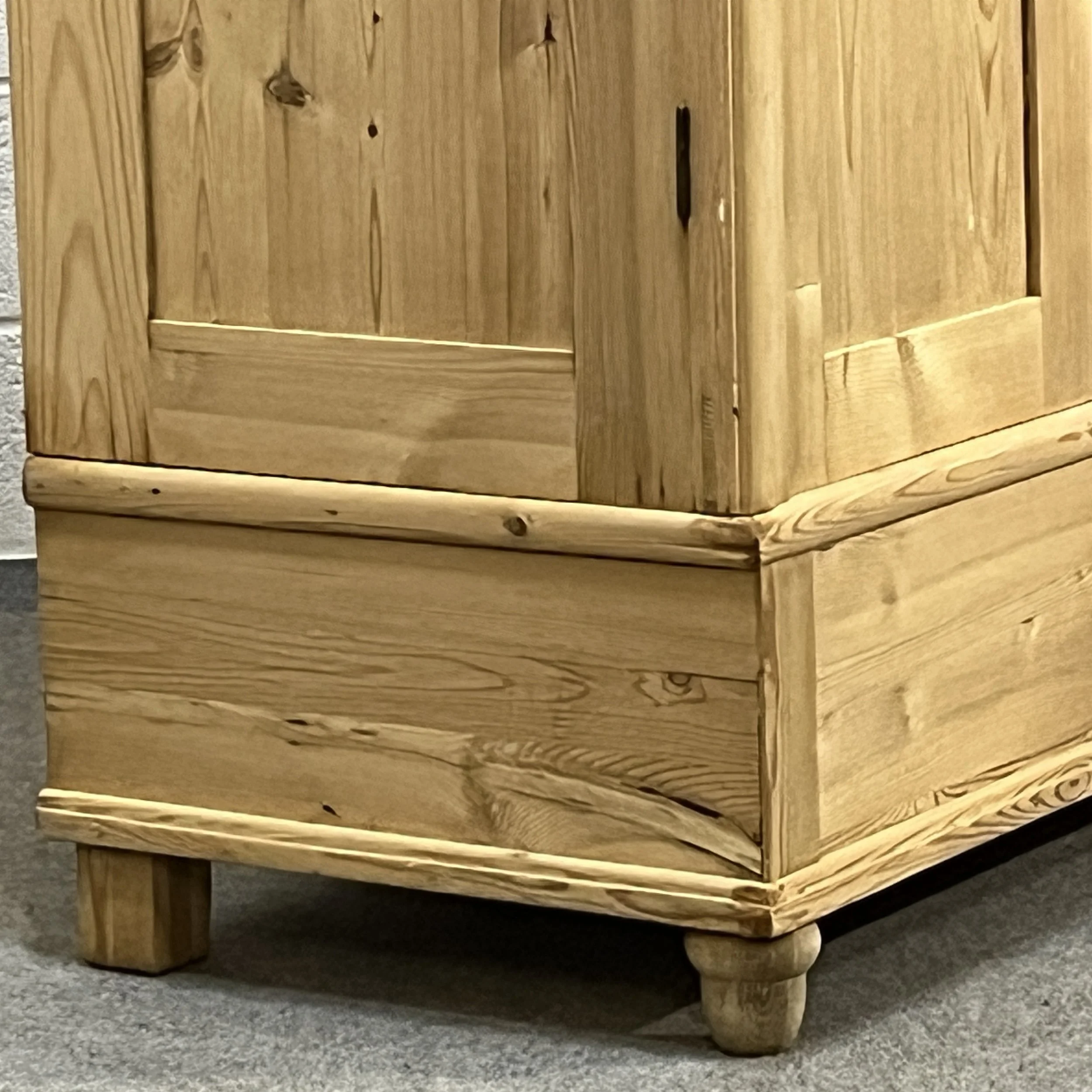 Detail of the pine wardrobe lower corner, drawer and short feet