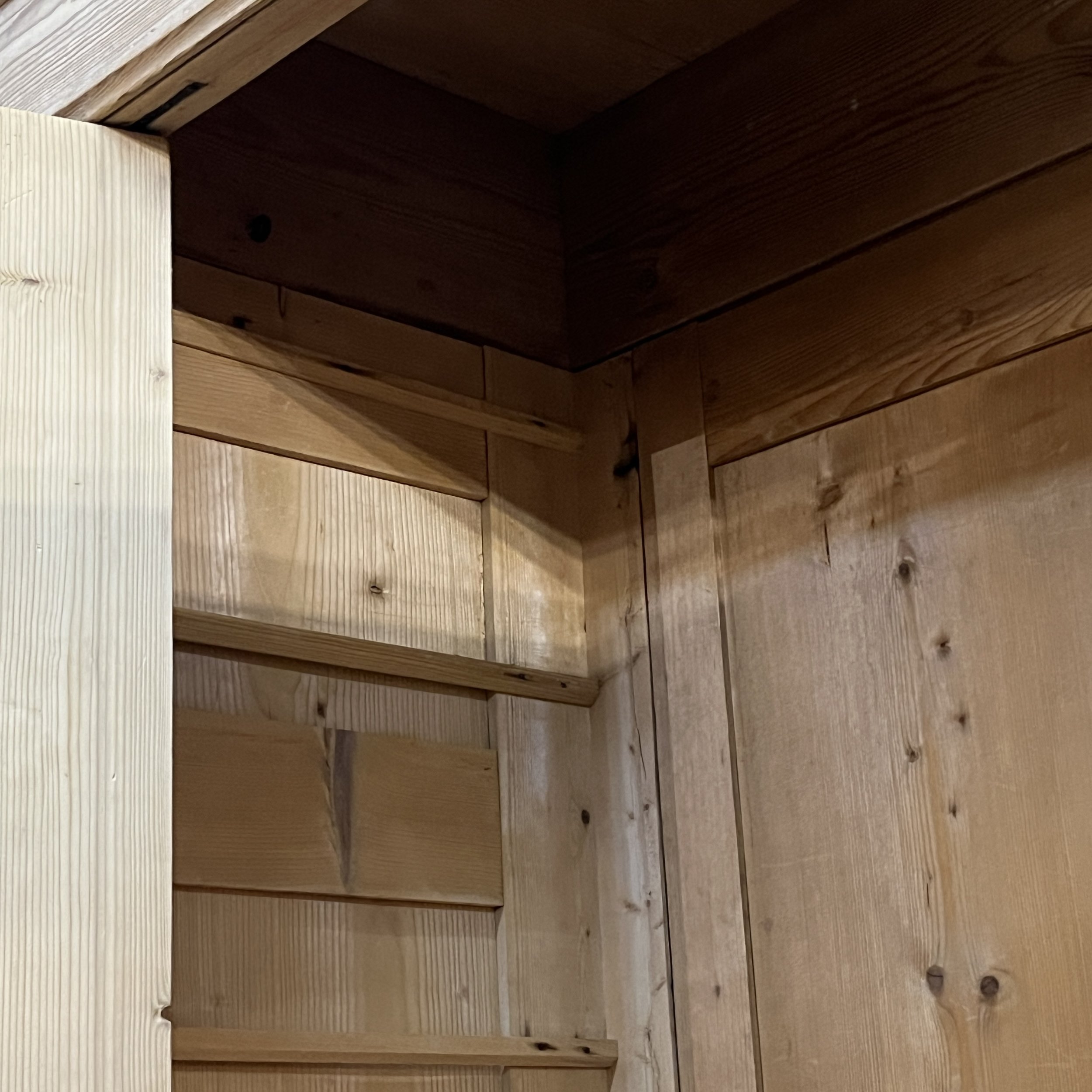 Upper interior corner of old pine wardrobe N8206H showing panelled construction and back boards.