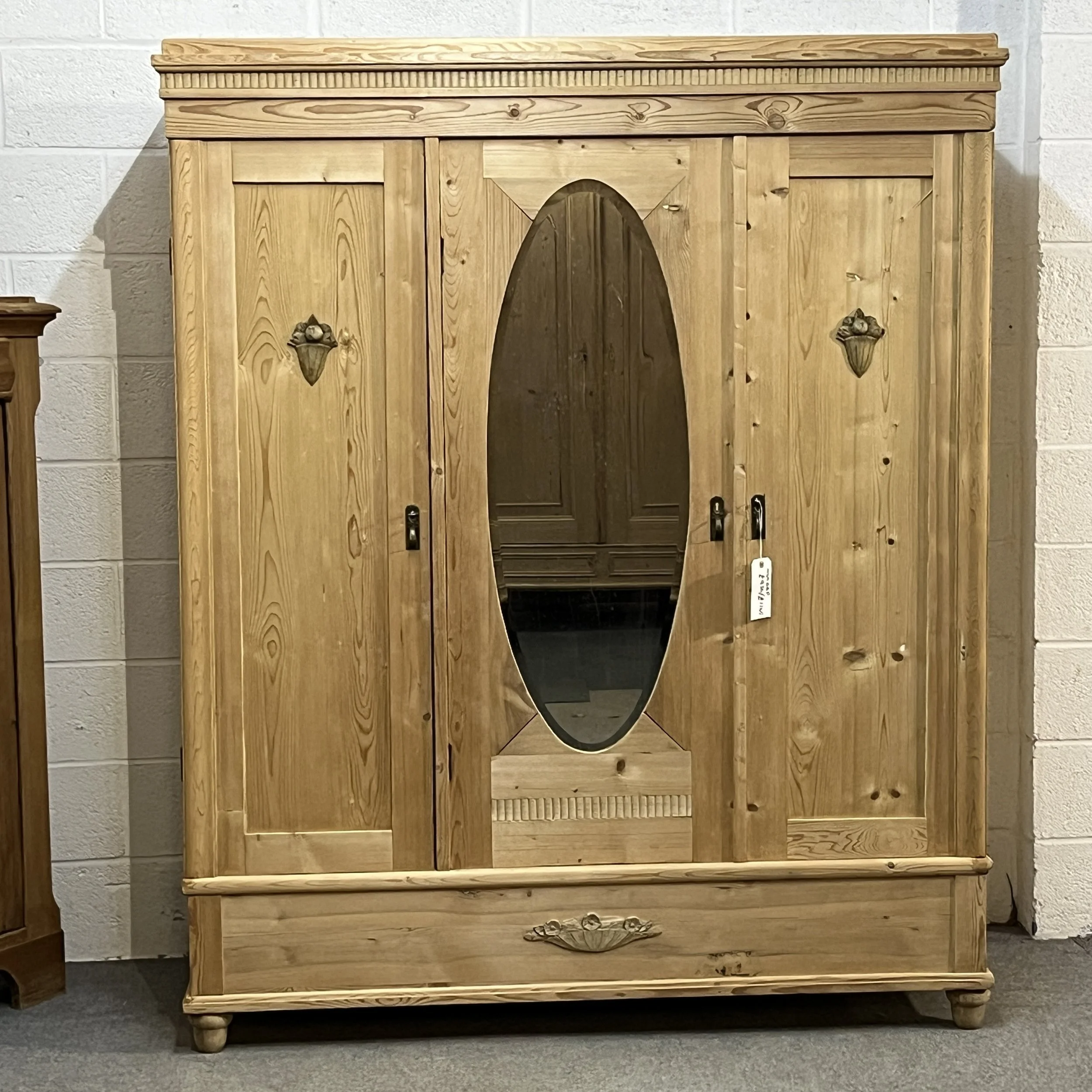 Front view of the triple pine wardrobe with oval mirror and full-width bottom drawer