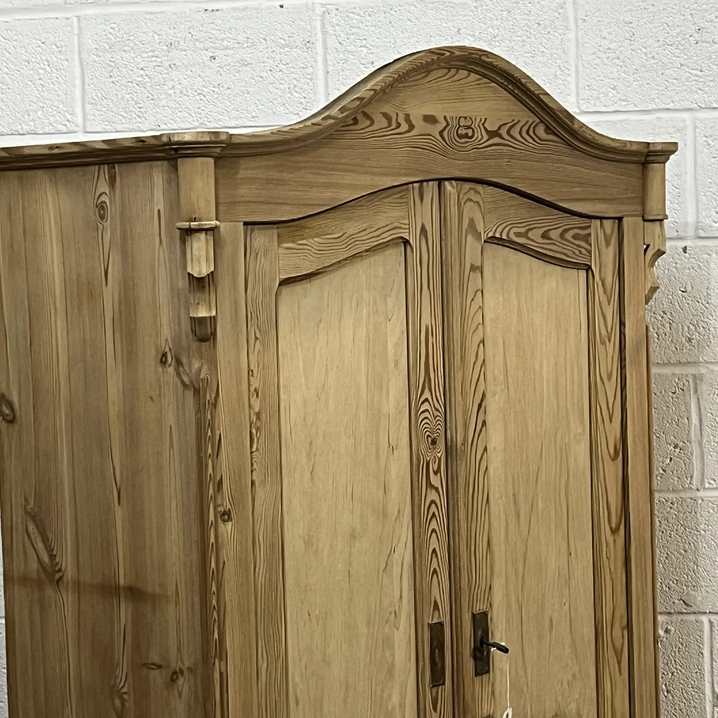 Detail of the arched cornice and door panels of pine armoire N3304D