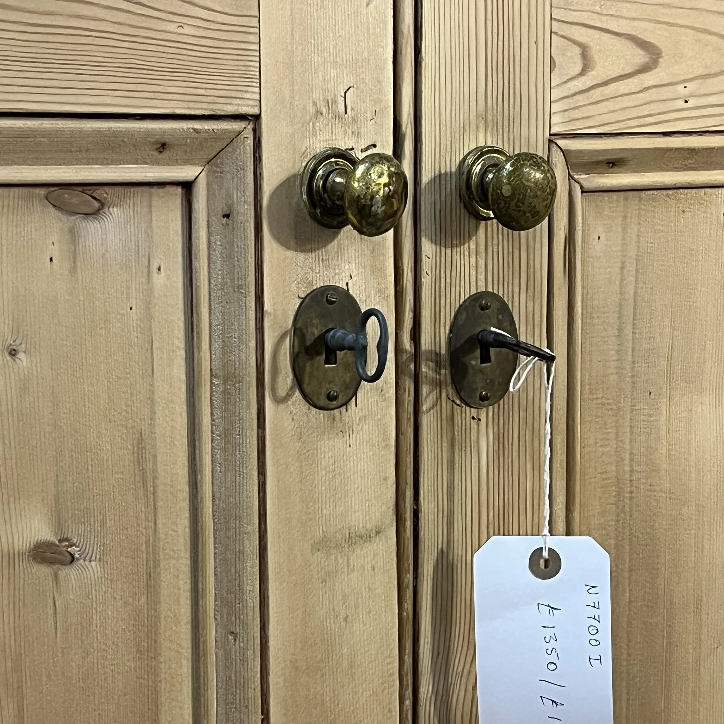 Upper door brass knobs, locks and keys on antique pine cupboard N7700I
