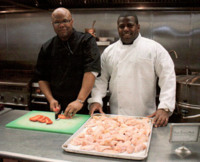 Carroll, left, with colleague, Douglas Spikes, cooking for Amos House during the Men Who Cook/Women who Judge cooking competition in March 2009.