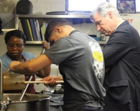 Bola and Abdullah mix the granola as Senator Whitehouse observes.