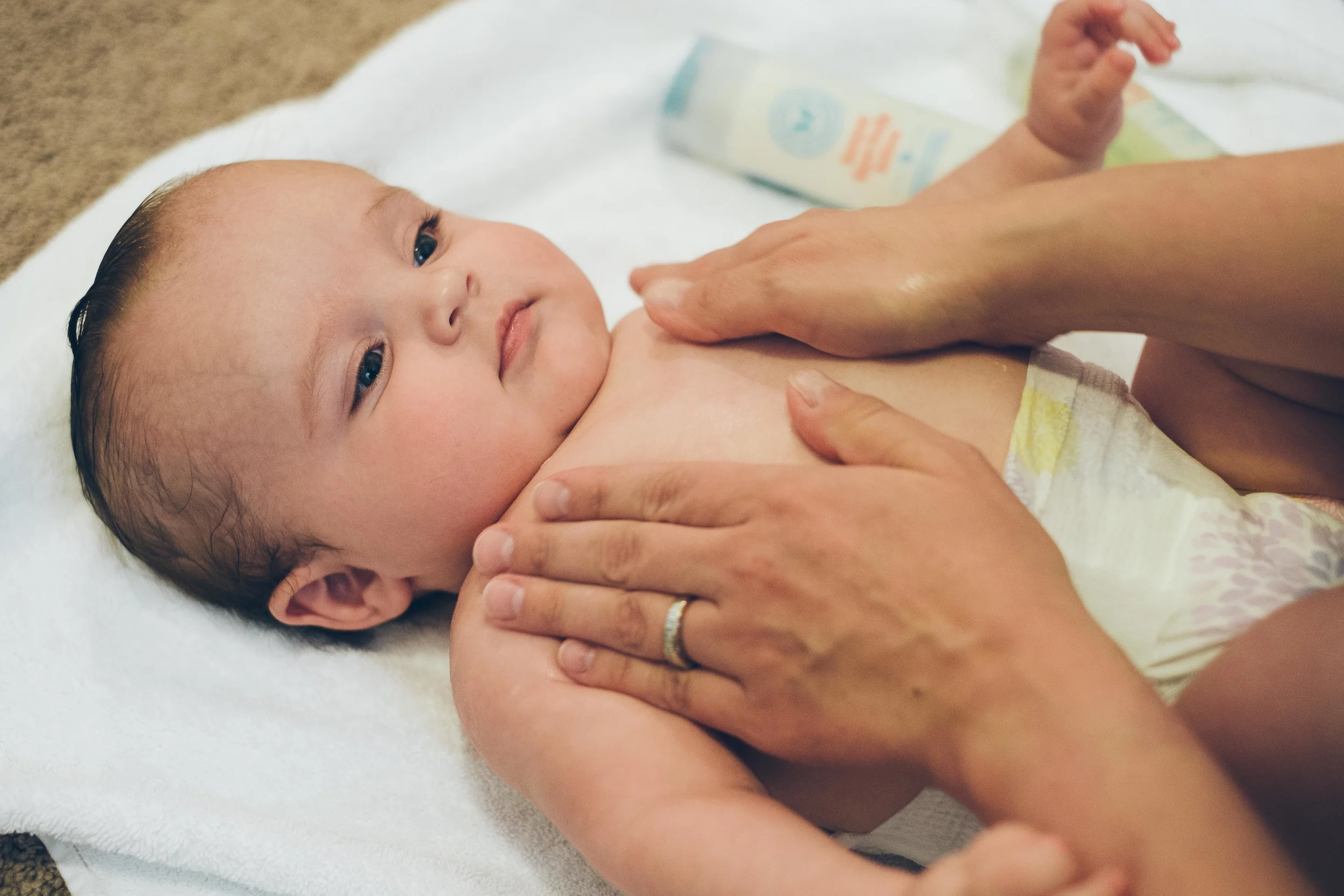 Rubbing lotion all over her skin. It's dry in Denver!