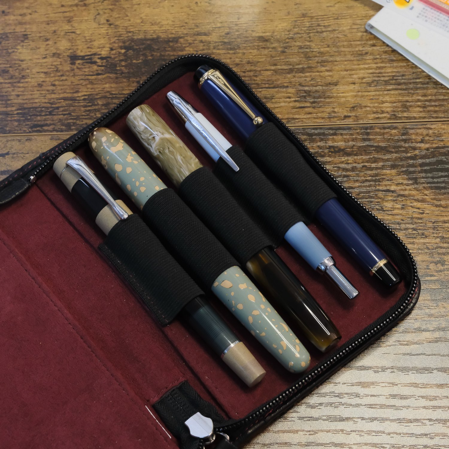 Joe's 2026 Pen Acquisitions displayed in a leather pen case, including an Opus 88, seY fountain pen, Bonecrusher7 Studios, Pilot Decimo, and Pilot Custom Urushi
