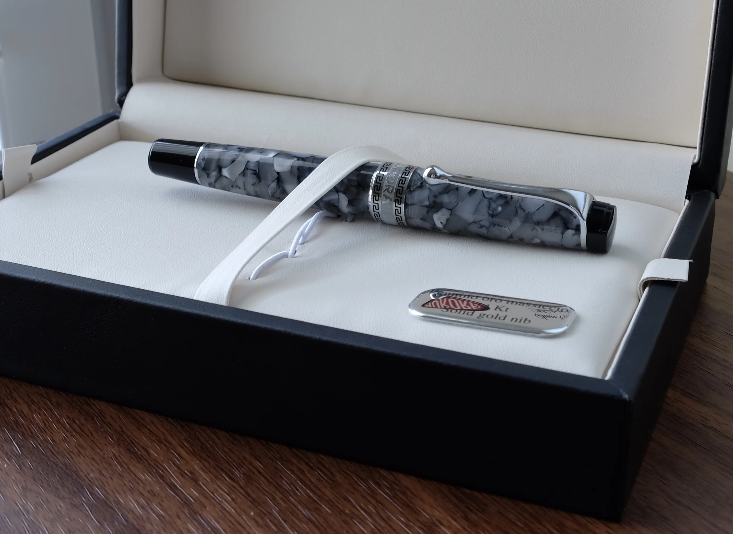 A close-up of the Optima in its box. You can get a sense of the translucency of the material if you look just below the cap, where you can tell the pen has been filled with blue ink. 