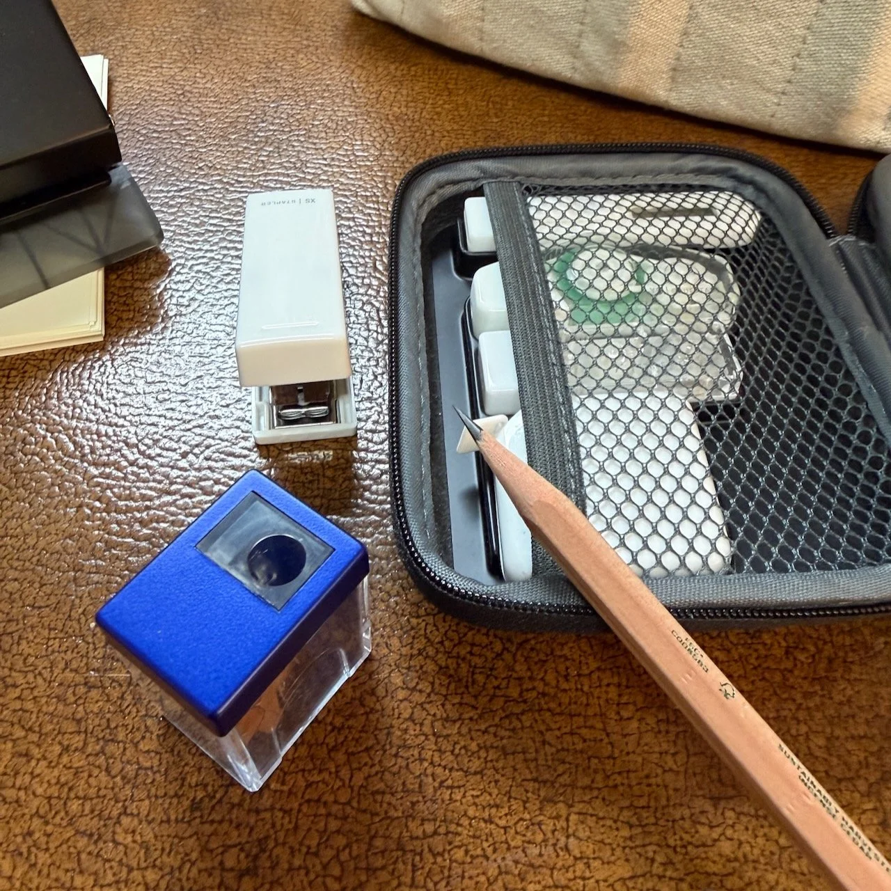 A photograph of a sharpened wood pencil next to an NJK Sharpener