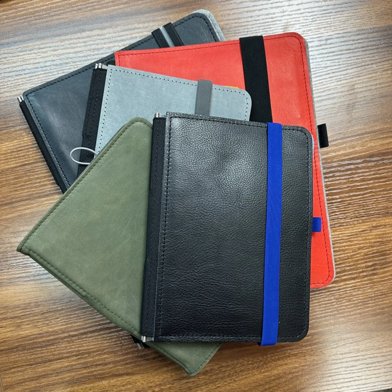 Roterfaden Taschenbegleiter Notebook Covers stacked on a desk in multiple sizes