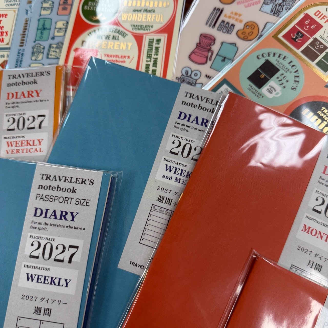 TRAVELER'S Company 2027 Diaries and Accessories piled on desk