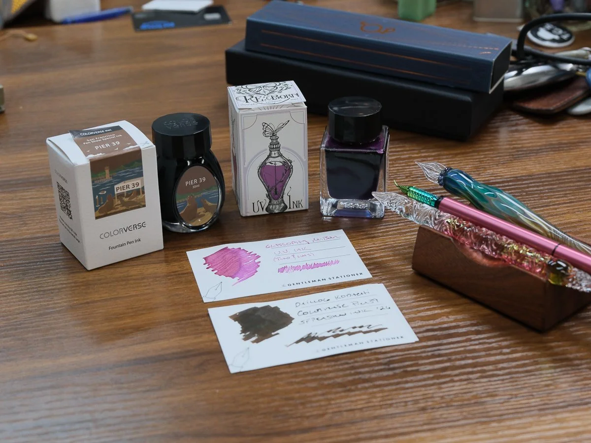 Glass Pens and Ink Bottles with Ink Swatches Sitting on a table