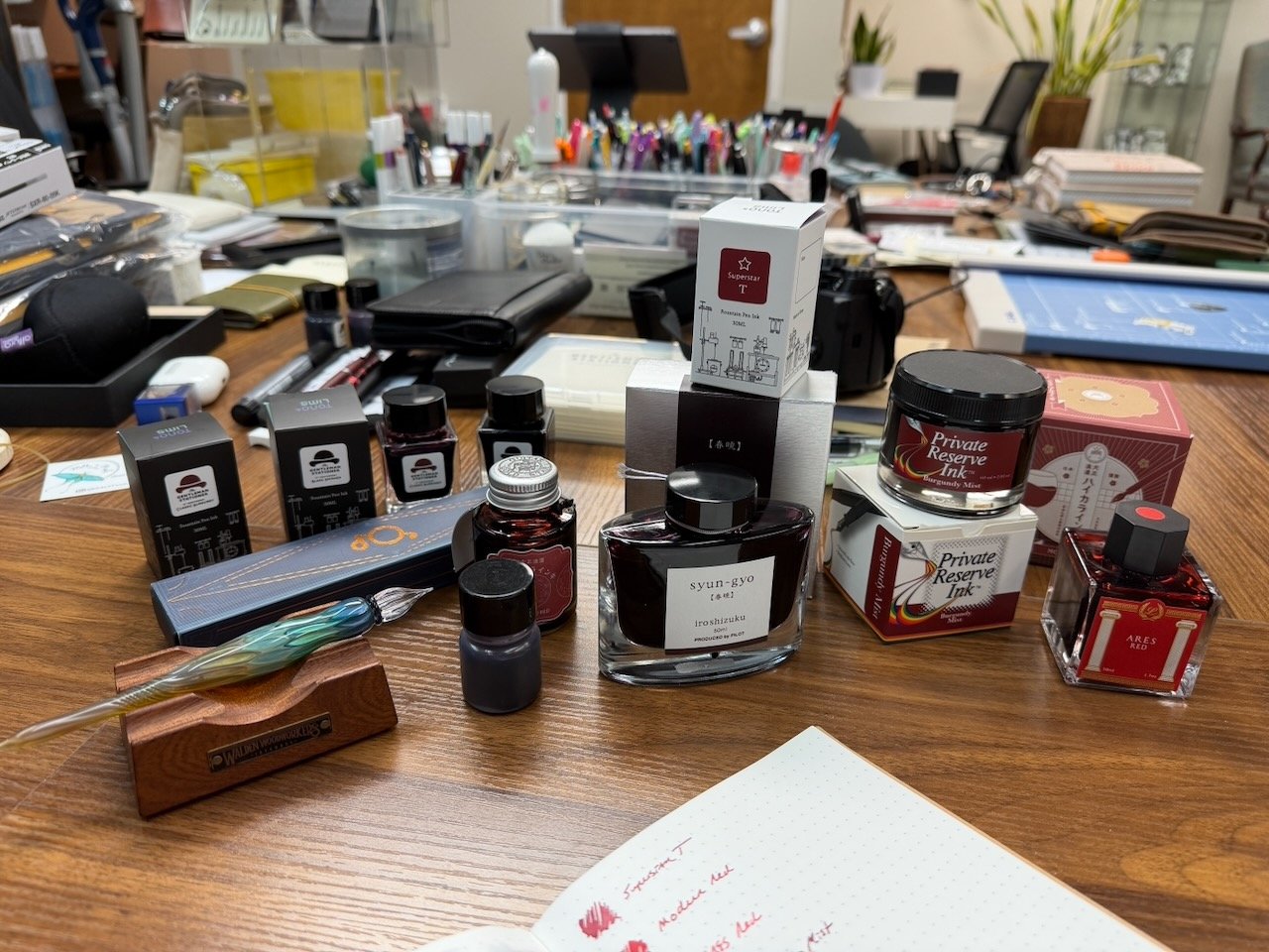 Red Inks and Swatch Supplies on Table with a Glass Dip Pen