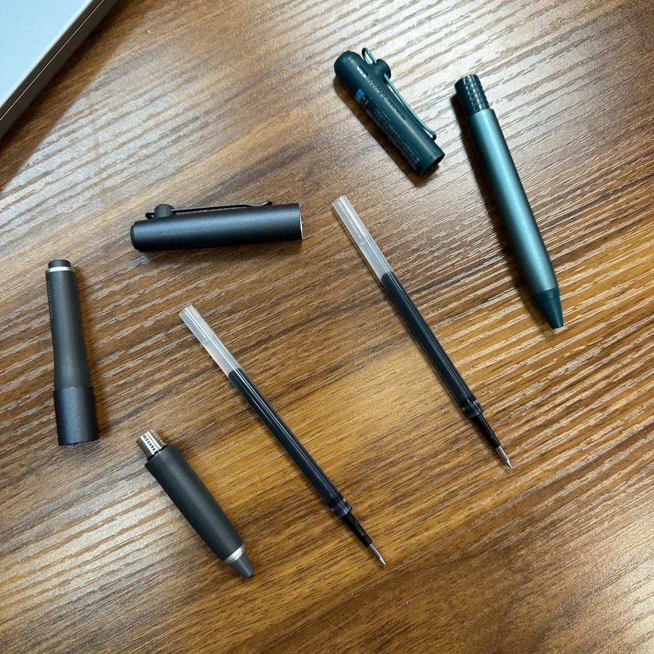 Uni Zento Refills in Disassembled Flow and Signature Pens on Desk