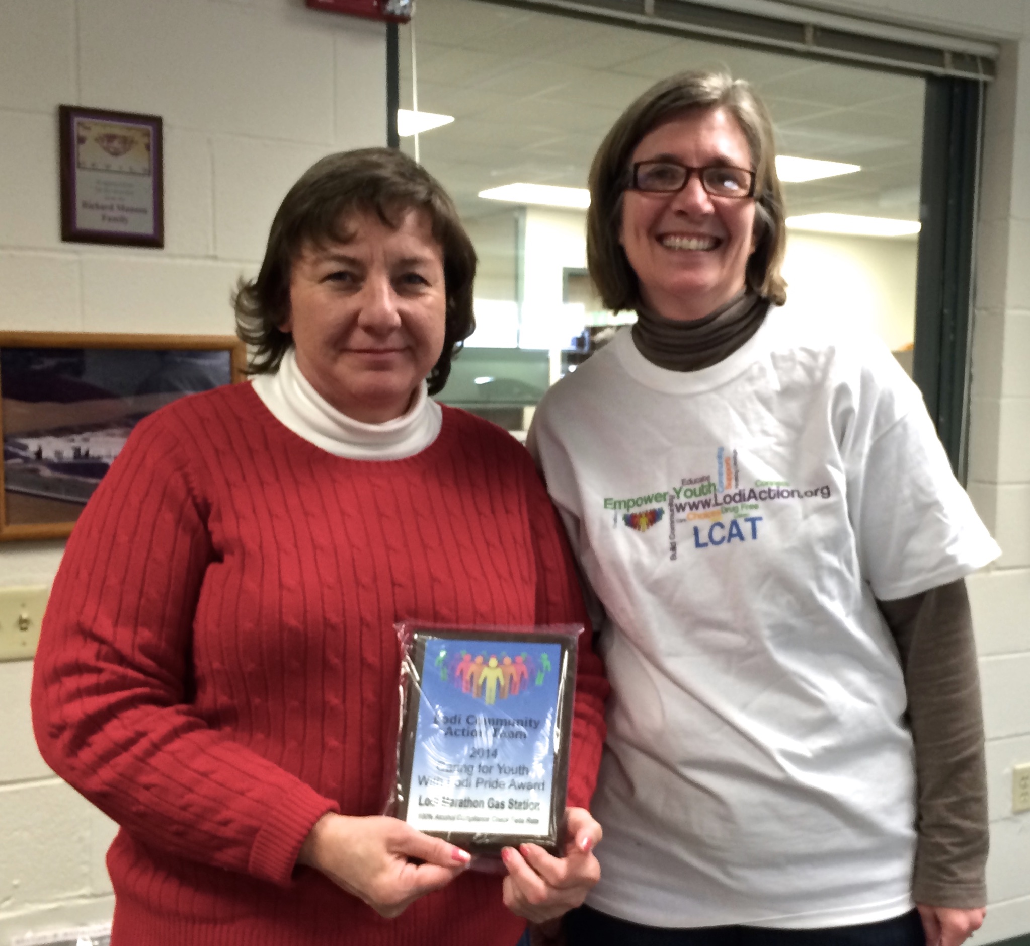 Paula Enger (right), LCAT Project Coordinator, presents a Lodi Pride Award to Jenny Anderson (left), Manager of the Lodi Marathon #303 gas station.