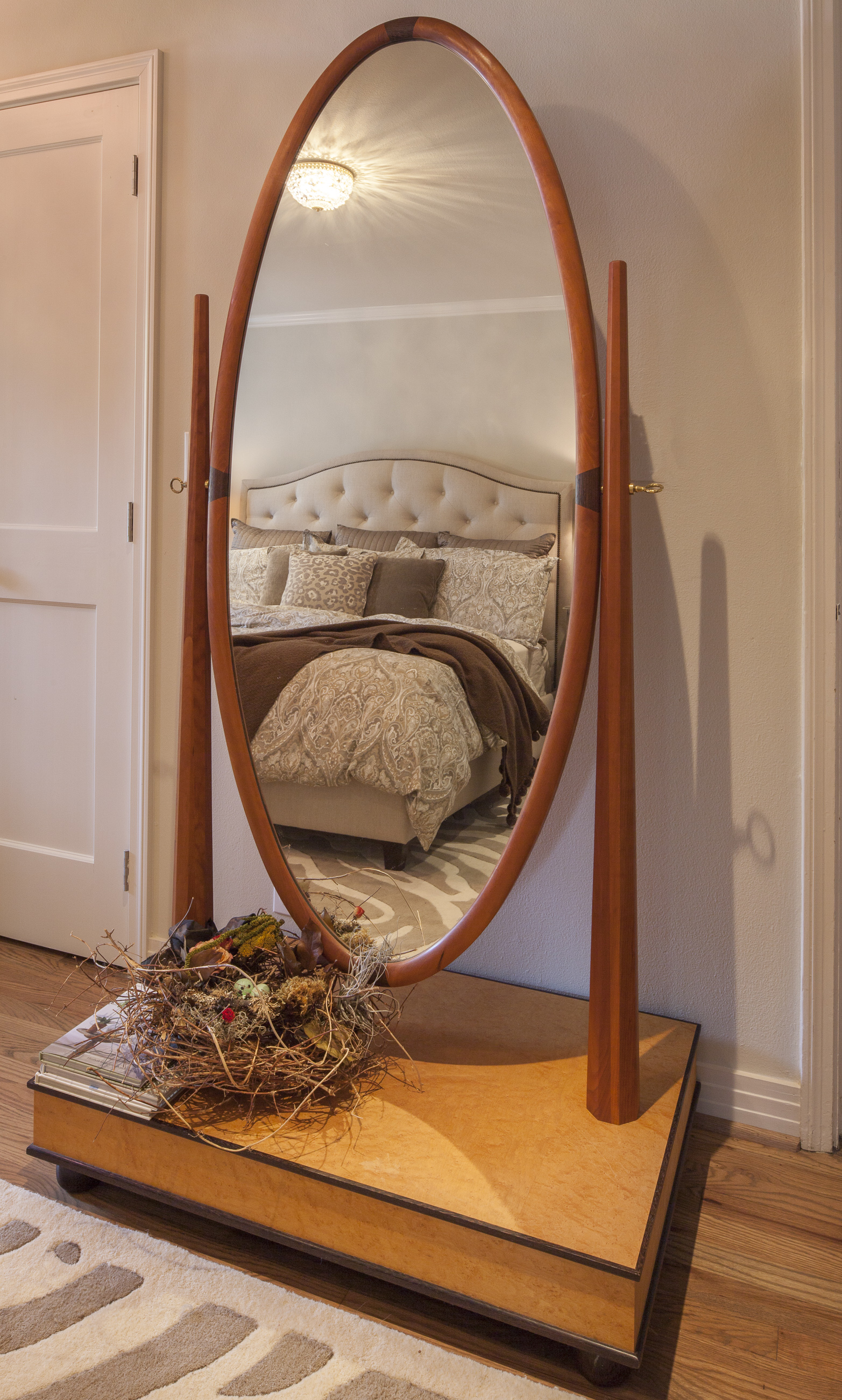 Cheval mirror of multiple woods: Base of birds-eye maple; base trim of African wenge; vertical supports of cherry and oval mirror also trimmed with cherry and an inlay of wenge. Design adapted by Michael Reznikoff/RCF.