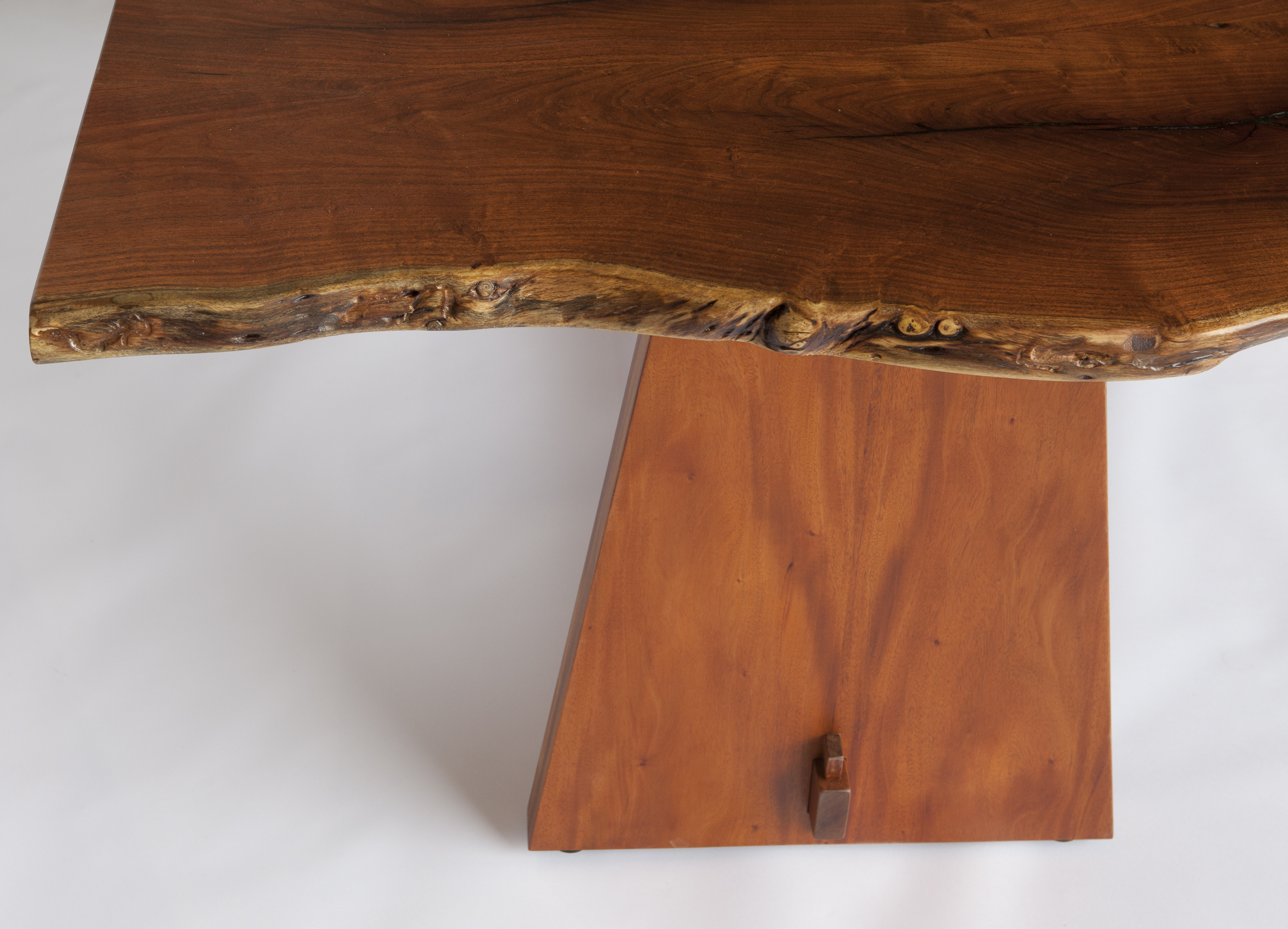 This "live-edge" table features slabs hewn from south Texas mesquite. It displays a tabletop dimension of 79" x 42" and stands 29" high. The african mahogany base follows a more contemporary "trestle" design. Design by Reznikoff Custom Furniture