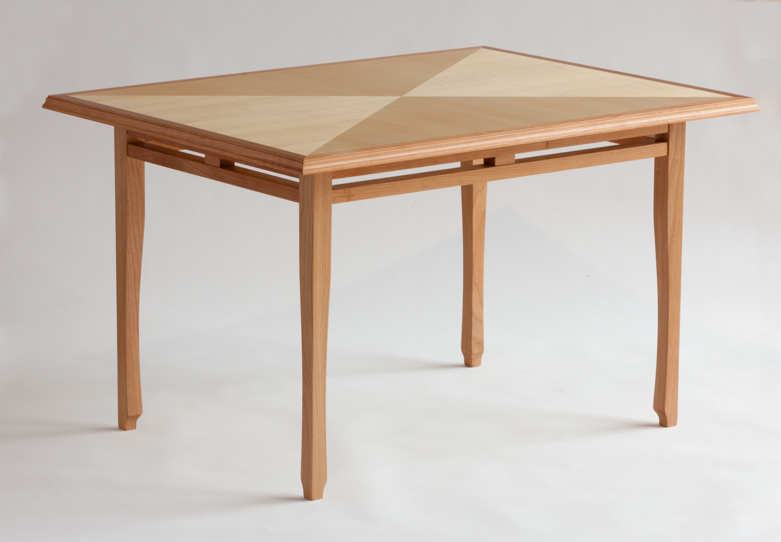 Coffee table of quarter-figured sycamore laid up in "reverse diamond" pattern with cherry edge, trim & base Learn more...
