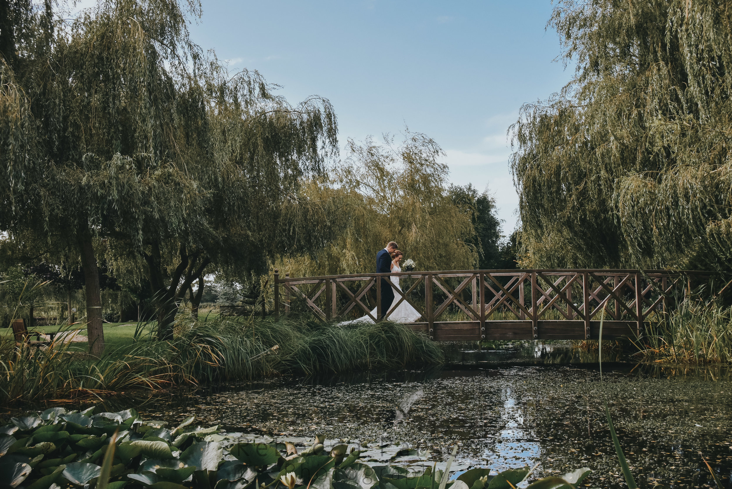 Bride and groom on bridge in sensory garden