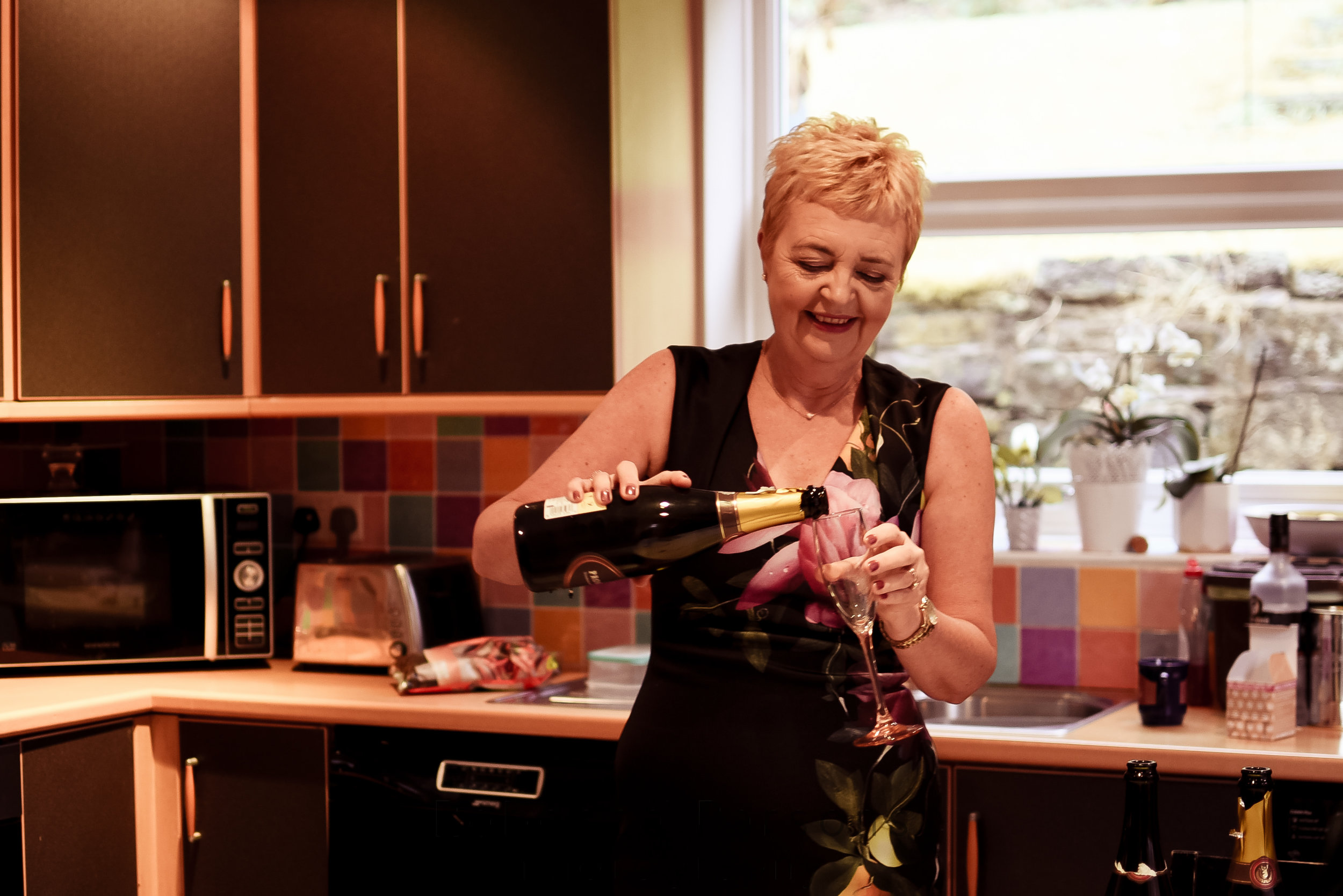 Mother of the bride pouring prosecco
