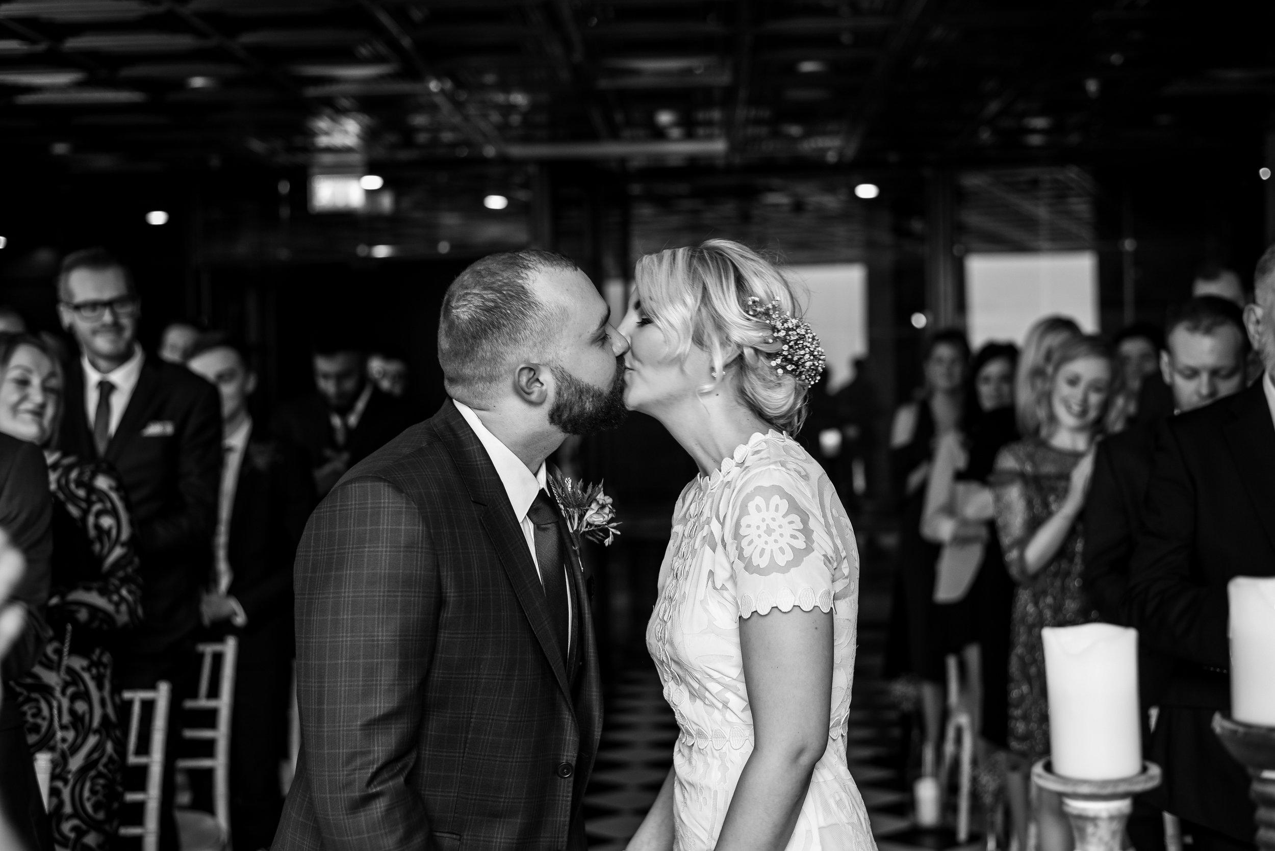 Bride and groom kissing at the altar