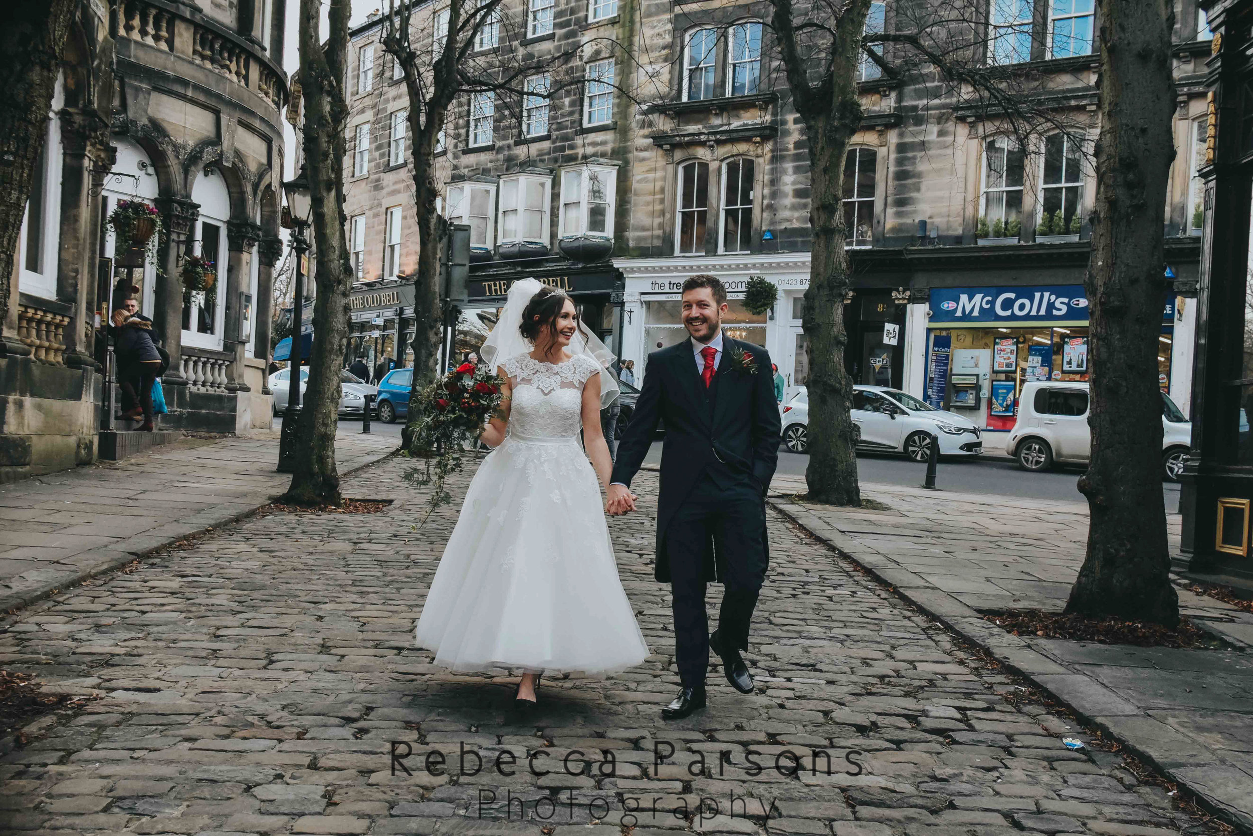 bride and groom walking down cobbled street