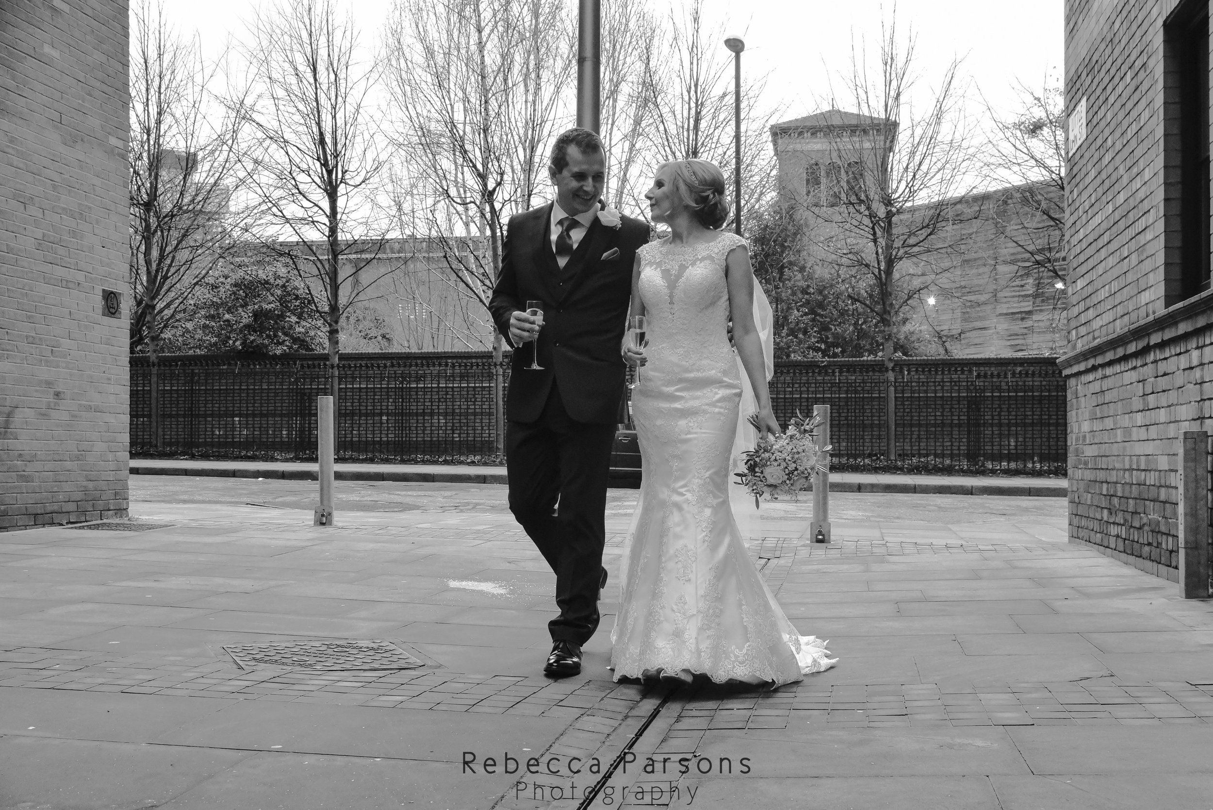 black and white bride and groom walking through Manchester