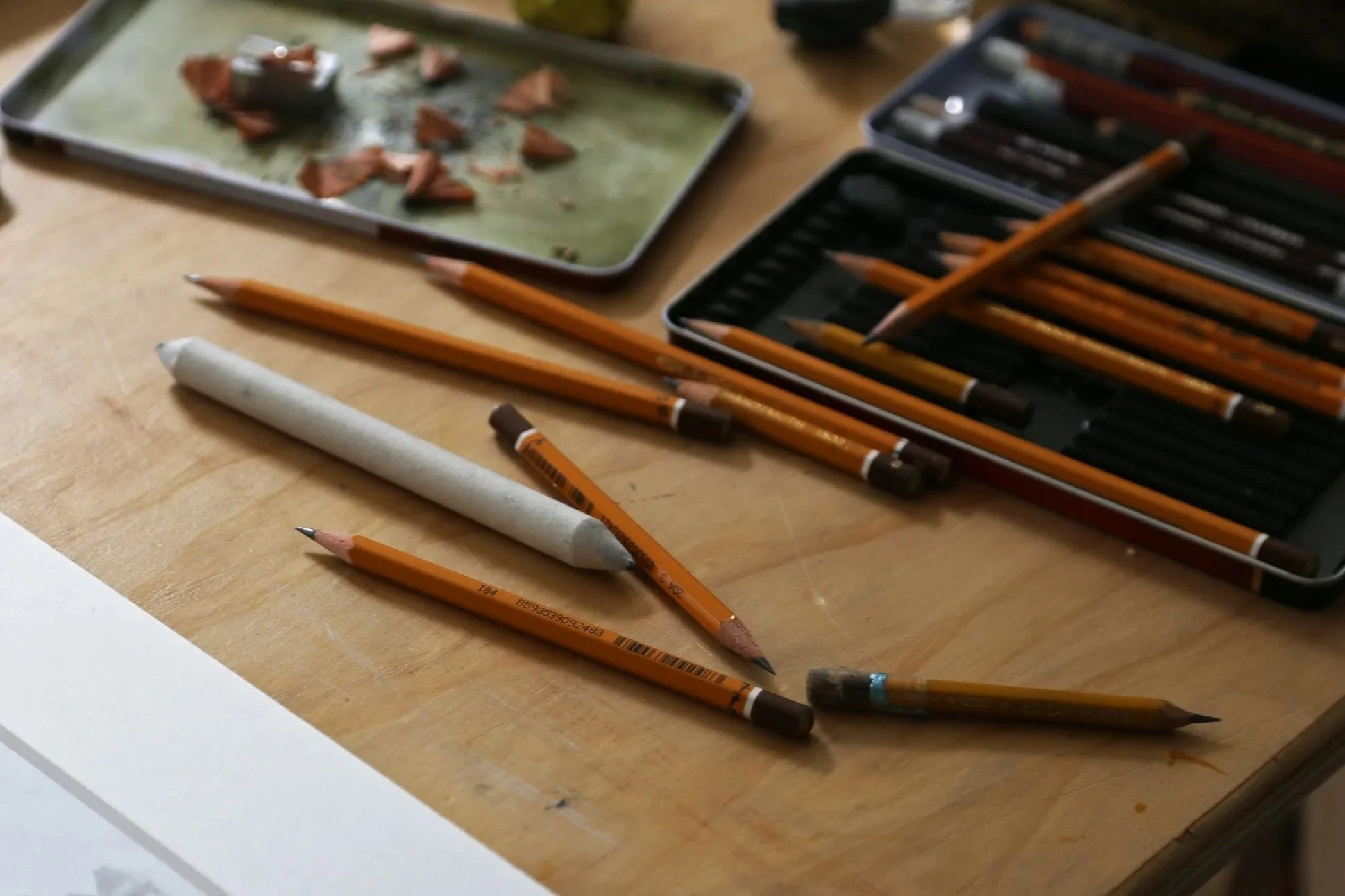 Een bureau waar een portret tekening wordt gemaakt, met potloden