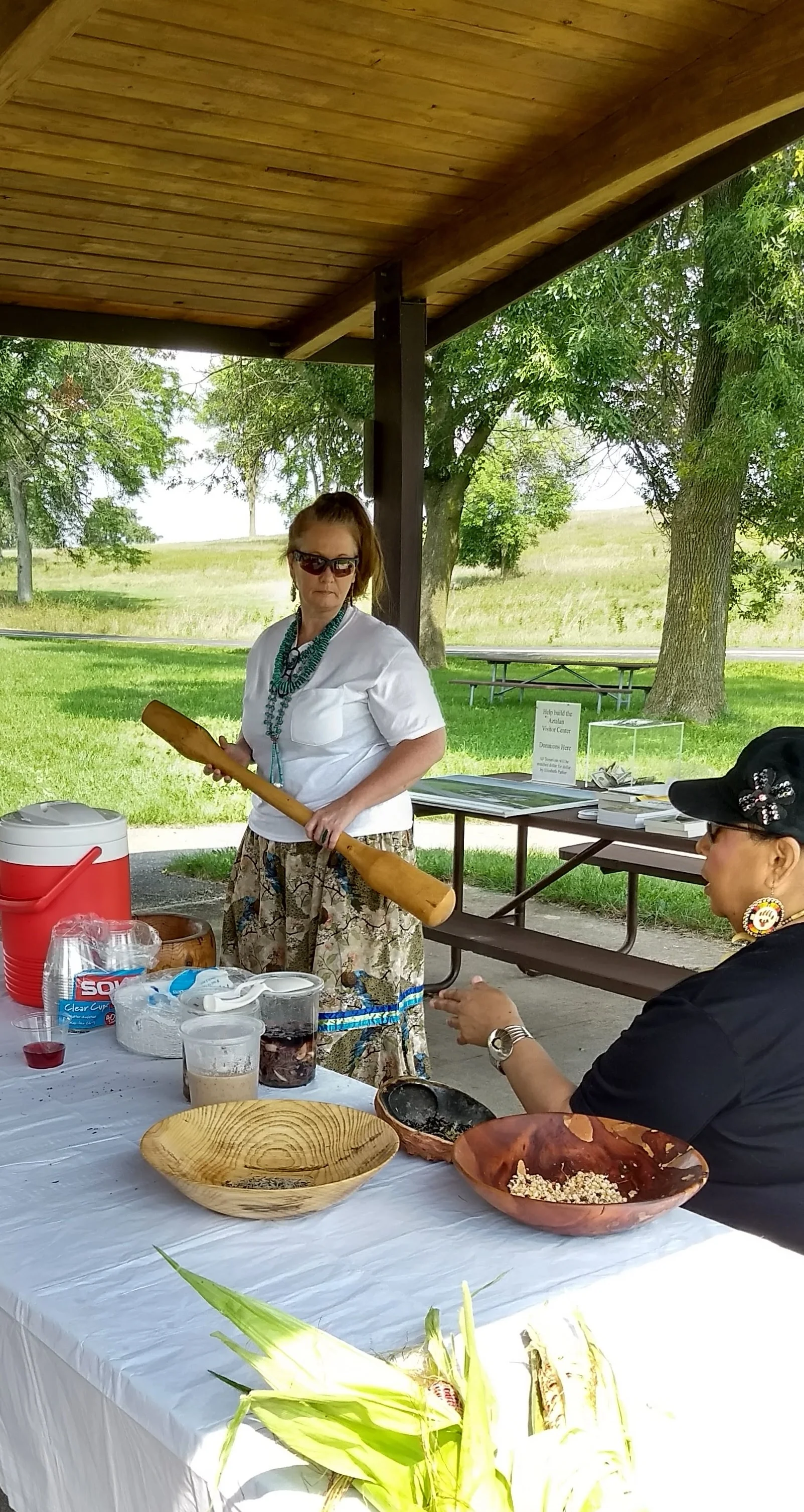 Rhonda Funmaker and Jodee Smith, with the corn pounder