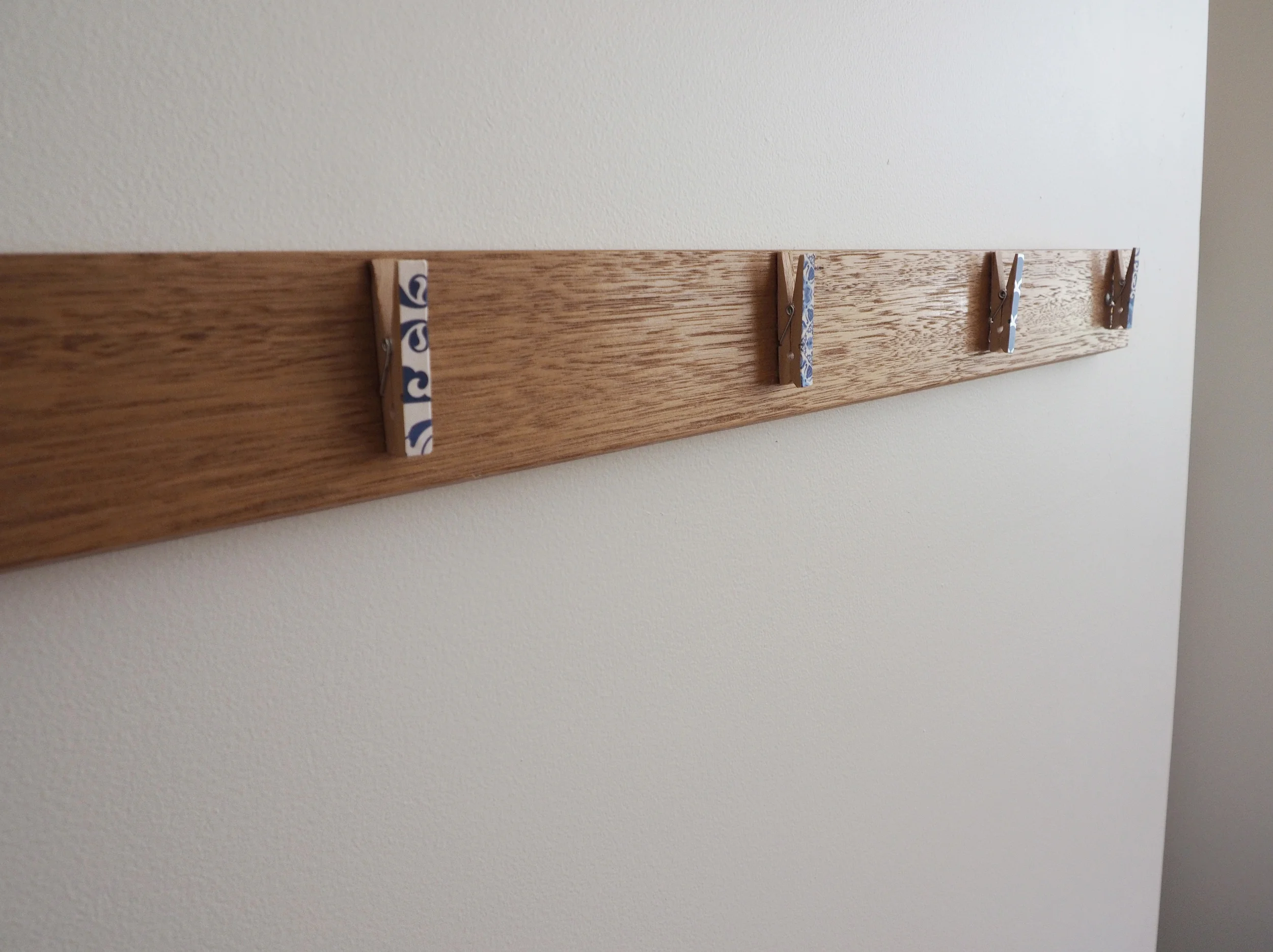 Decorative mini-pegs attached to a simple piece of wood is the perfect way to display child's artwork