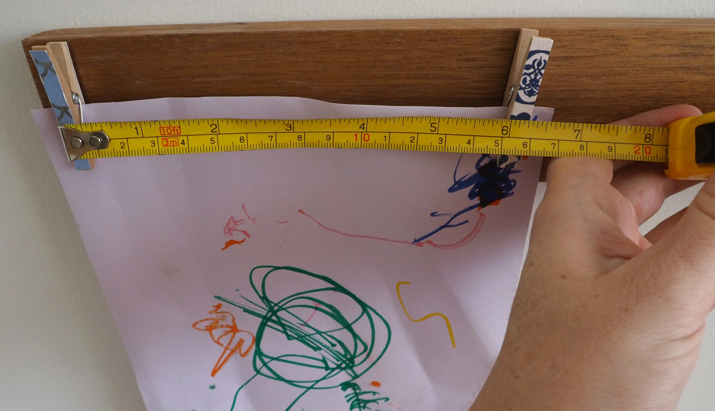 Measuring distance between the pegs to hold artwork efficiently